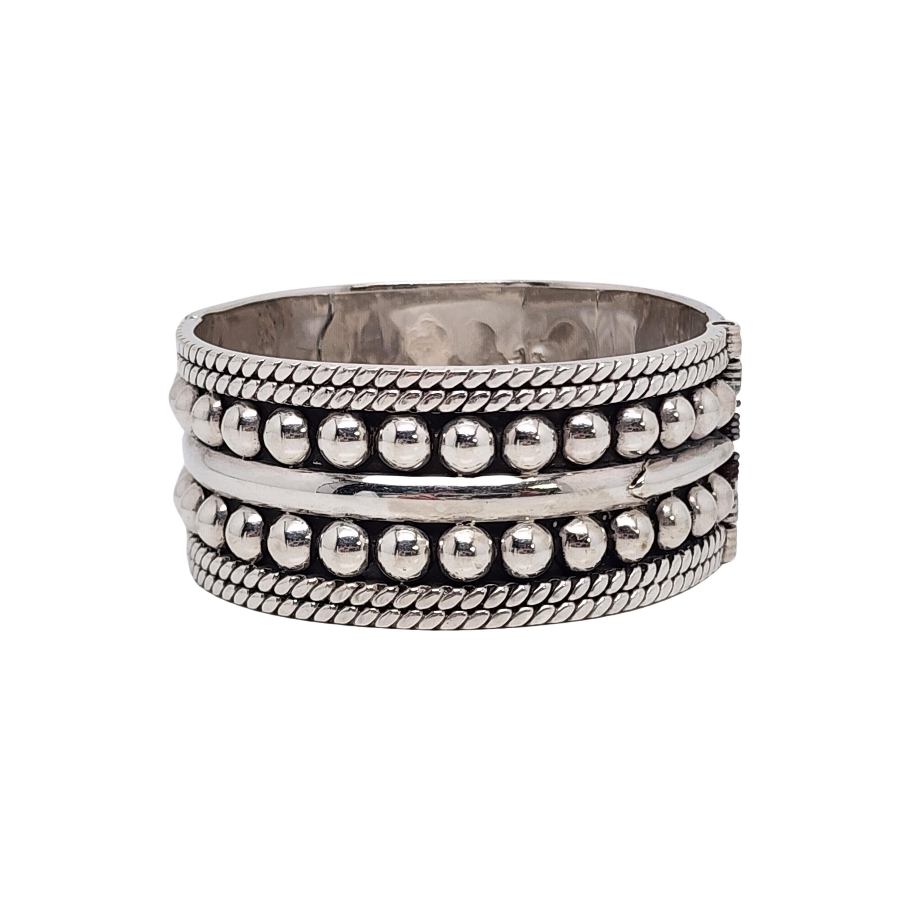 Sterling silver wide hinged bangle bracelet by Taxco, Mexico artisan.

A large and significant bracelet featuring a double row of bead design and textured rope edging.

Weighs approx 68.4g, 44.0dwt

Measures approx 7 