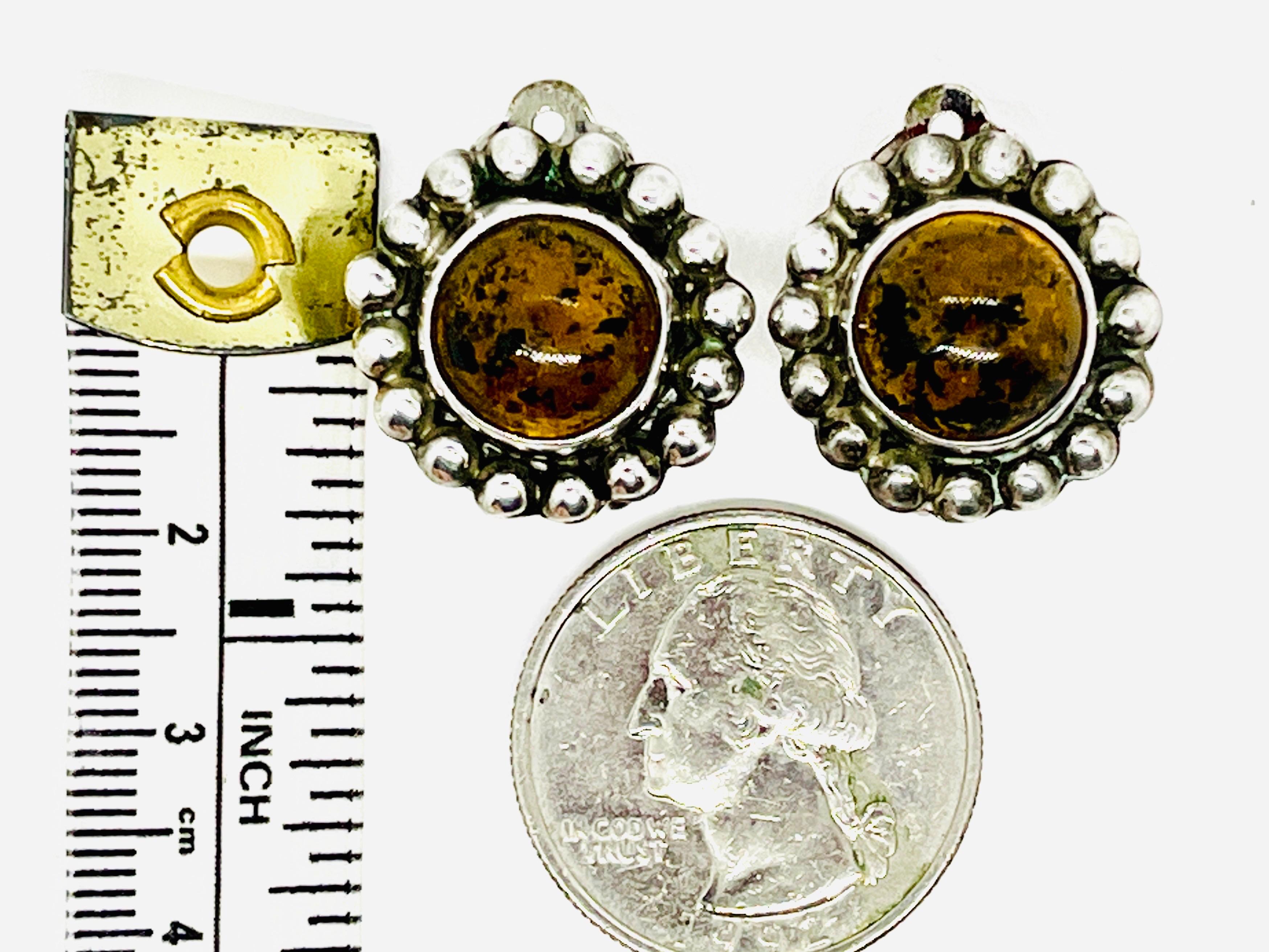 Pair of Chiapas yellow amber cabochon inlayed Taxco silver earrings with silver ball halo detail. 925 Mexican silver. One earring is marked “MEX TT-47 MEX” The second is marked “MEX TT-47 925”.

The first letter, T, is the city letter for Taxco. The
