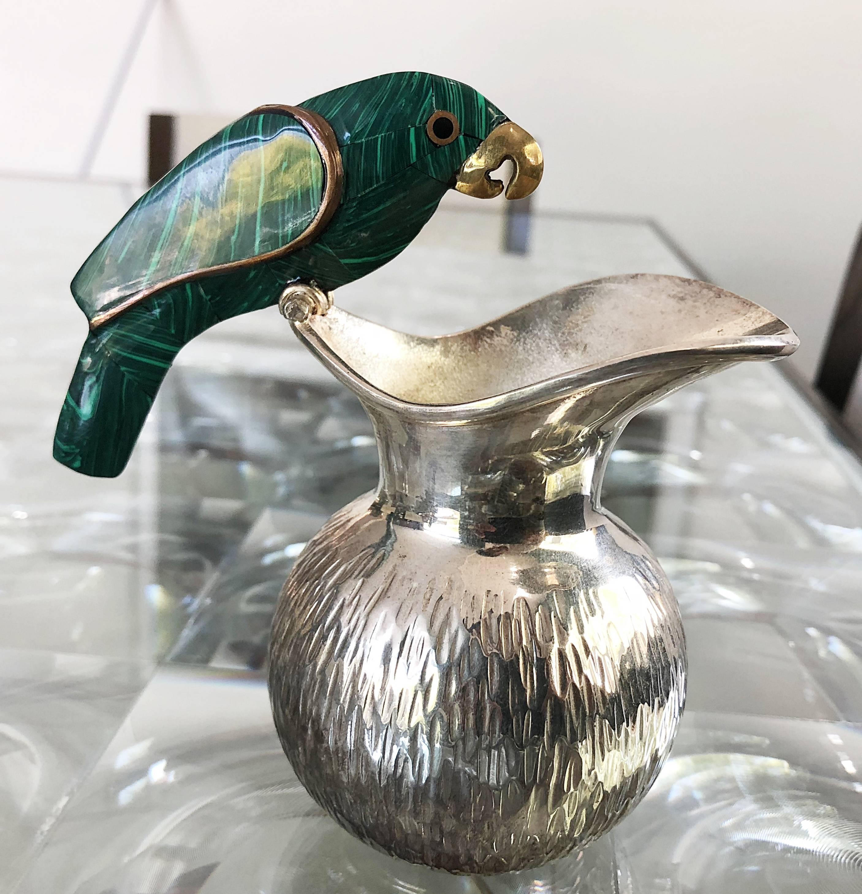 Vintage serving set in silver, malachite and brass by Los Fajardo of Taxco.
The creamer and sugar caddie are beautifully adorned with a parrot perching on the rim of the bowl and pitcher, the parrot is made out of malachite and brass and is in