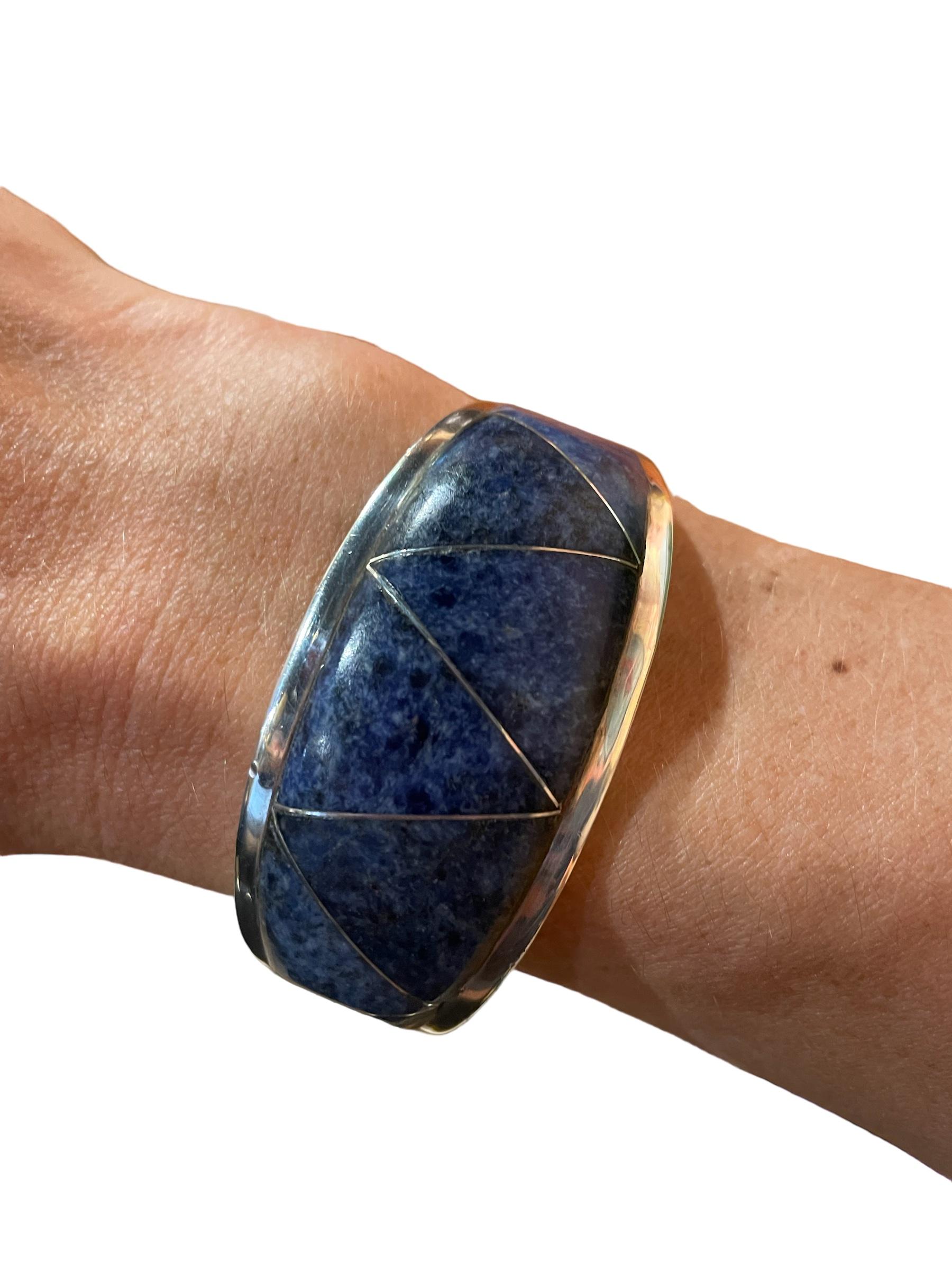 Taxco Sodalite 950 Sterling Silver Clamper Bracelet 

An amazing genuine Taxco blue sodalite and 950 sterling silver bangle-style hinged bracelet handmade and designed by Taxco artisan Alicia De La Paz. 

Weighs 78 grams and is stamped Alicia TD-40