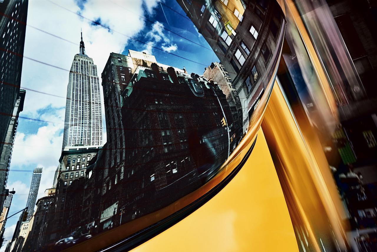 Part of the Reflections collection released by Spanish photographer Cuco de Frutos in 2019. This original photograph captures the Empire State building in the rear window of a yellow cab, one of New York’s most recognizable icons, timeless in its