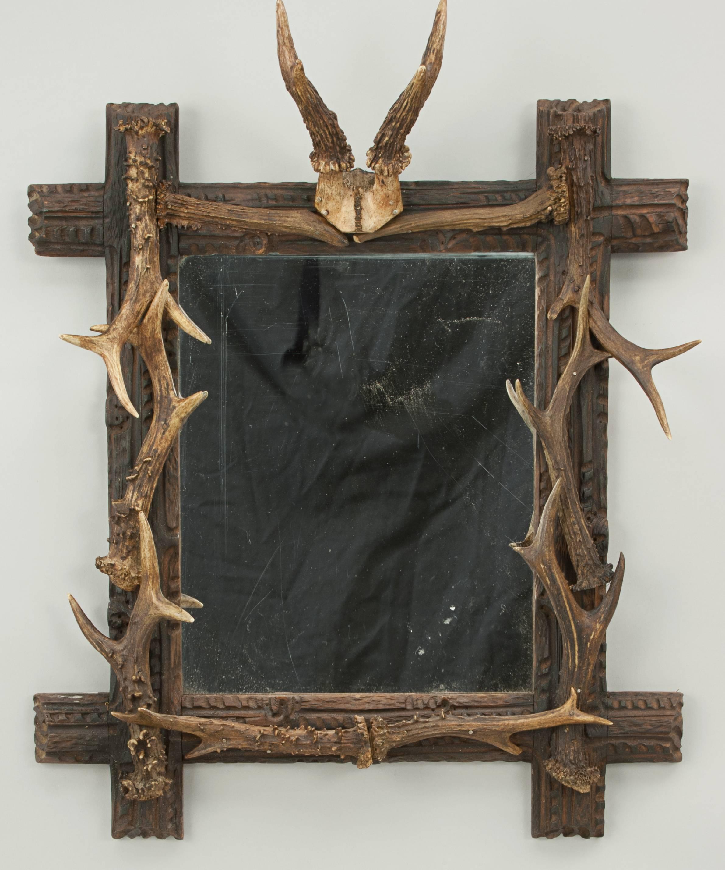 A fine Black Forest style wall mirror decorated with roe deer antlers. The 'Oxford' framed mirror is made of lime wood and has a small scull cap with antlers top centre, with several antlers fix around the outside. A rather attractive taxidermy