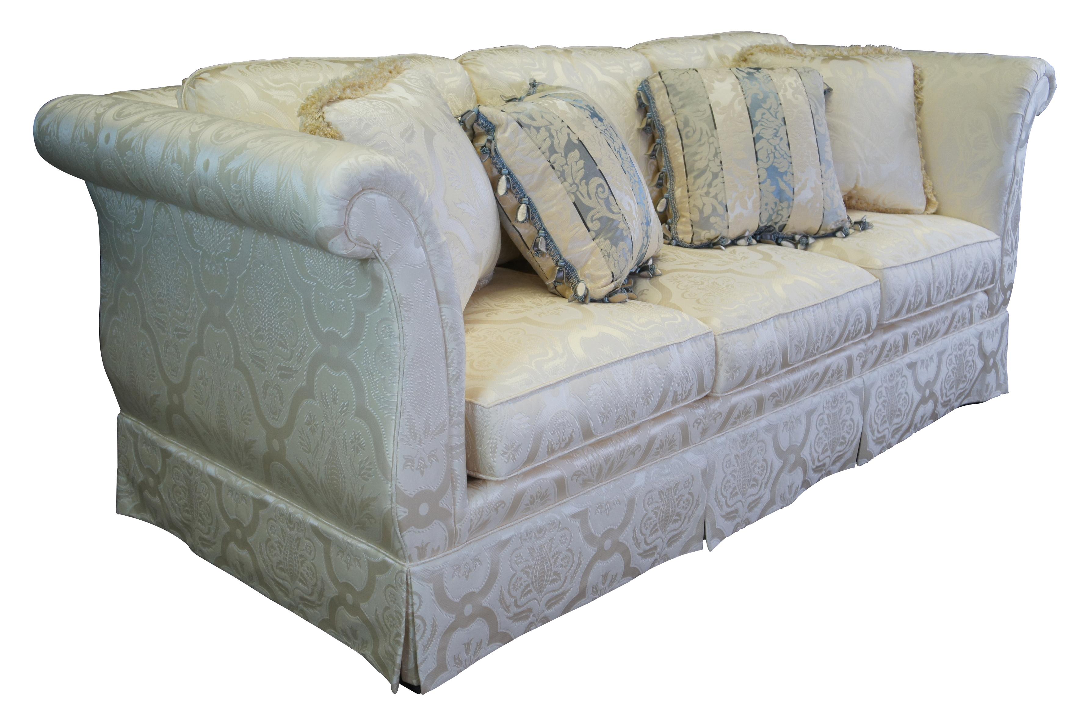 Vintage Taylor King three seat sofa or couch featuring a down filled silk Damask fabric with skirted base and high rolled arms and back.  Includes lumbar pillows with tulip tassels.  White / off-white / silver / blue.

Dimensions:
40