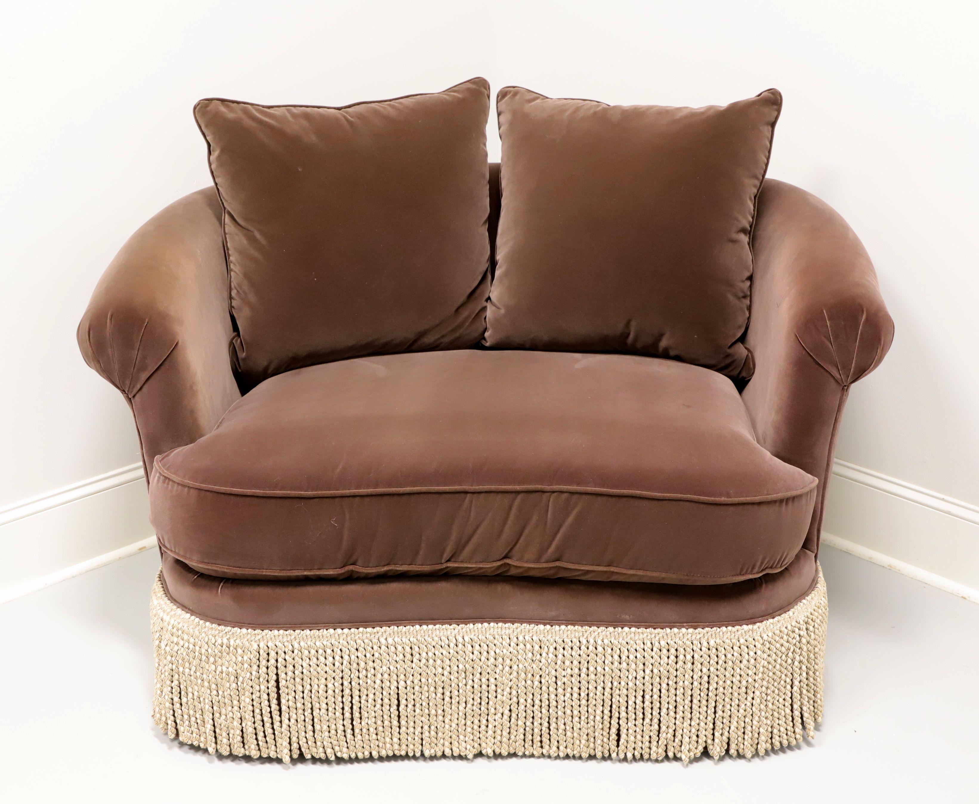 A Contemporary style swivel chair-and-a-half by Taylor King. Solid wood frame, oversized, fully upholstered in a soft velvety brown color fabric, Dual removable back pillows, rolled arms, beige bullion fringe at bottom, and easily rotated on a