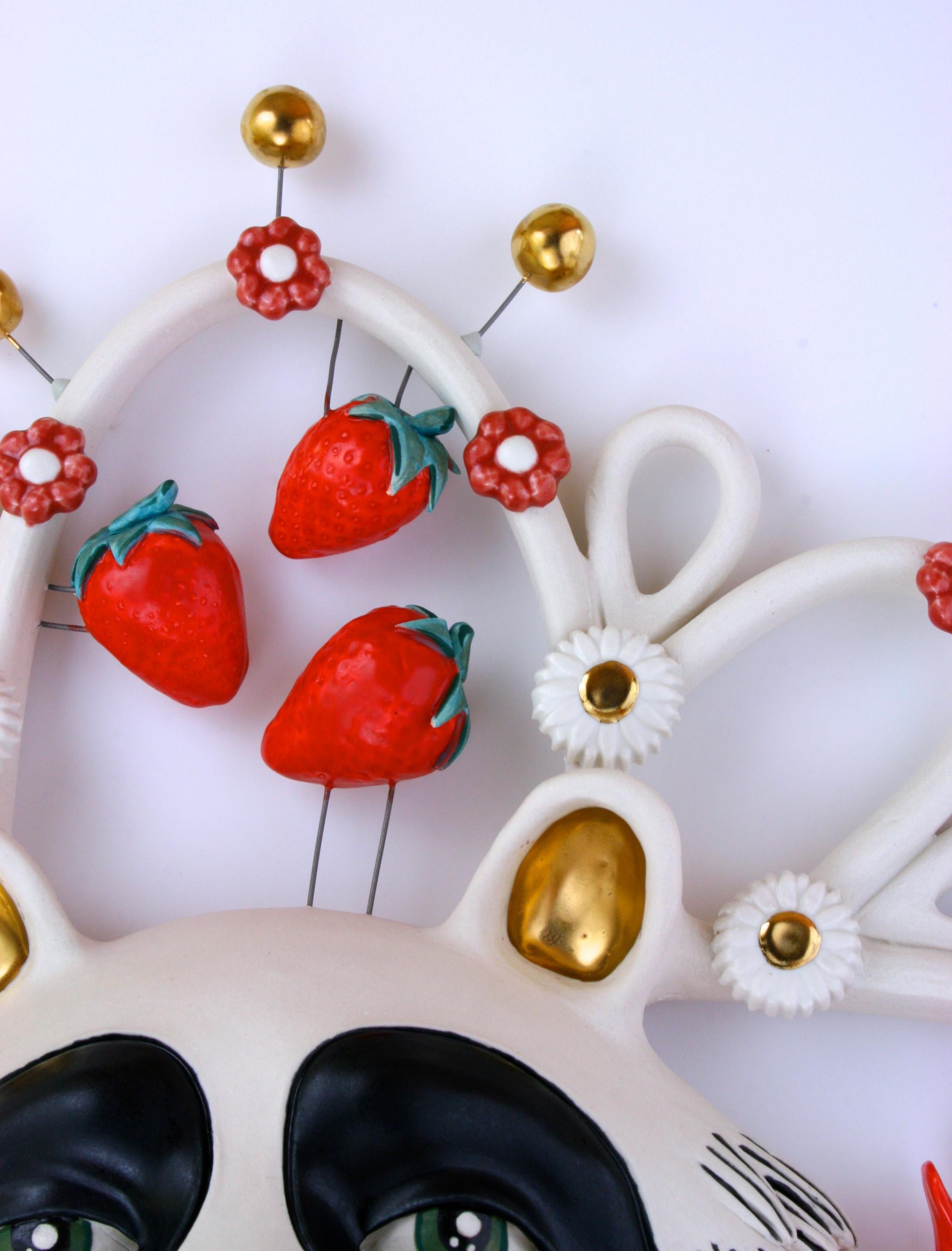 Ceramic sculpture of raccoon, strawberries, cardinals and flowers hand-built with porcelain, nichrome wire, glaze, underglaze and luster

