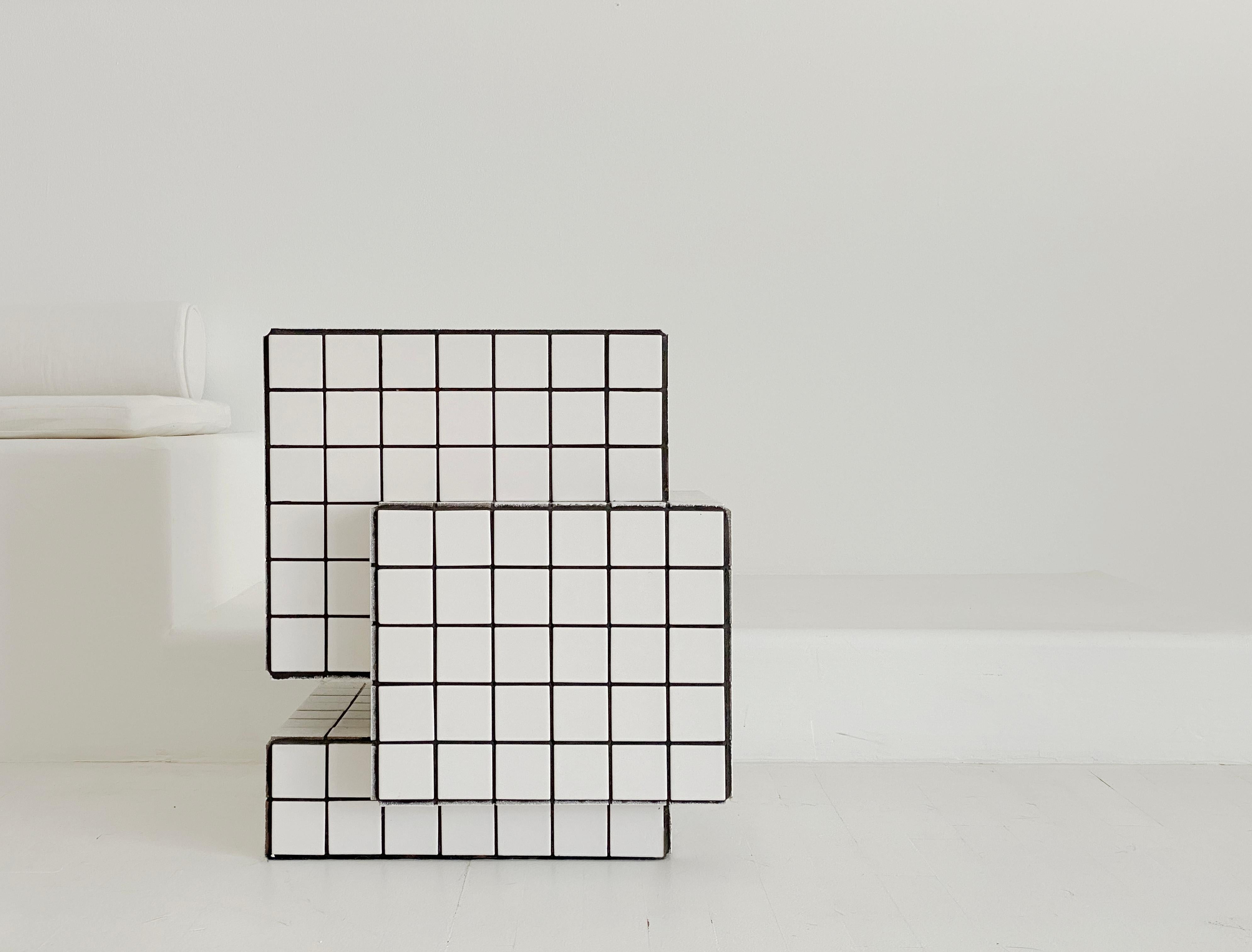 Designed and made by Nima Abili in Los Angeles this handcrafted side table is cladded with white semi-matte porcelain tiles and unsanded black grout. Inspired by Brutalist style of architecture this collection offers a variety of pieces designed