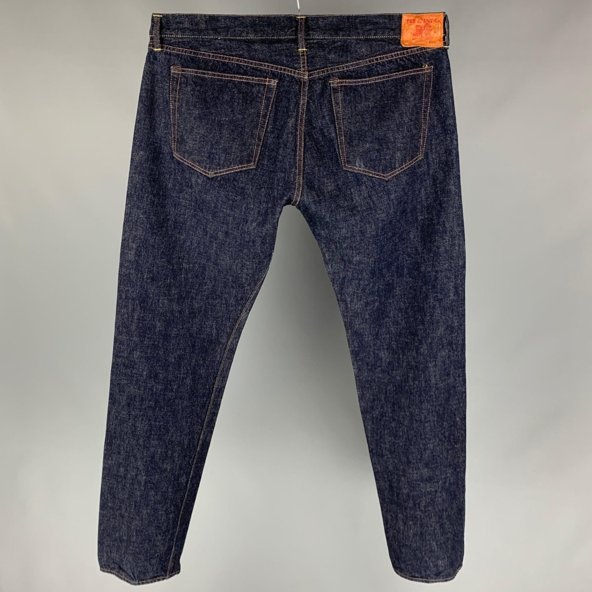 Le pantalon TCB Jeans se décline en denim selvedge indigo et présente une jambe droite, des coutures contrastées et une braguette à boutons. Fabriqué au Japon.
Très bien
Etat d'occasion. 

Marqué :   Etiquette de taille enlevée.  

Mesures : 
 