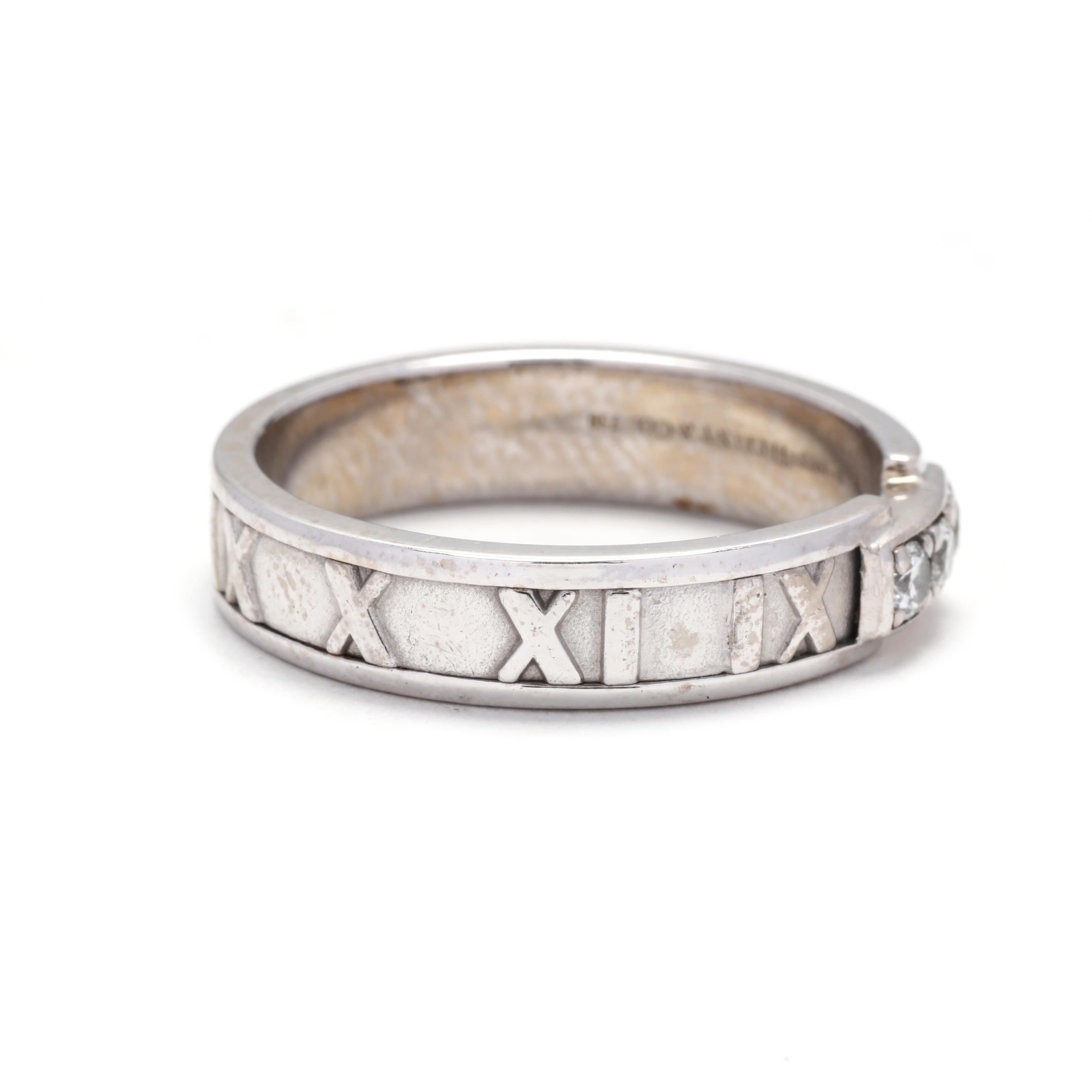 A vintage 18 karat white gold diamond band by Tiffany and Company. This ring features an eternity design with Roman numeral motifs through out and set with three round brilliant cut diamonds weighing approximately .15 total carats.



Stones:

-