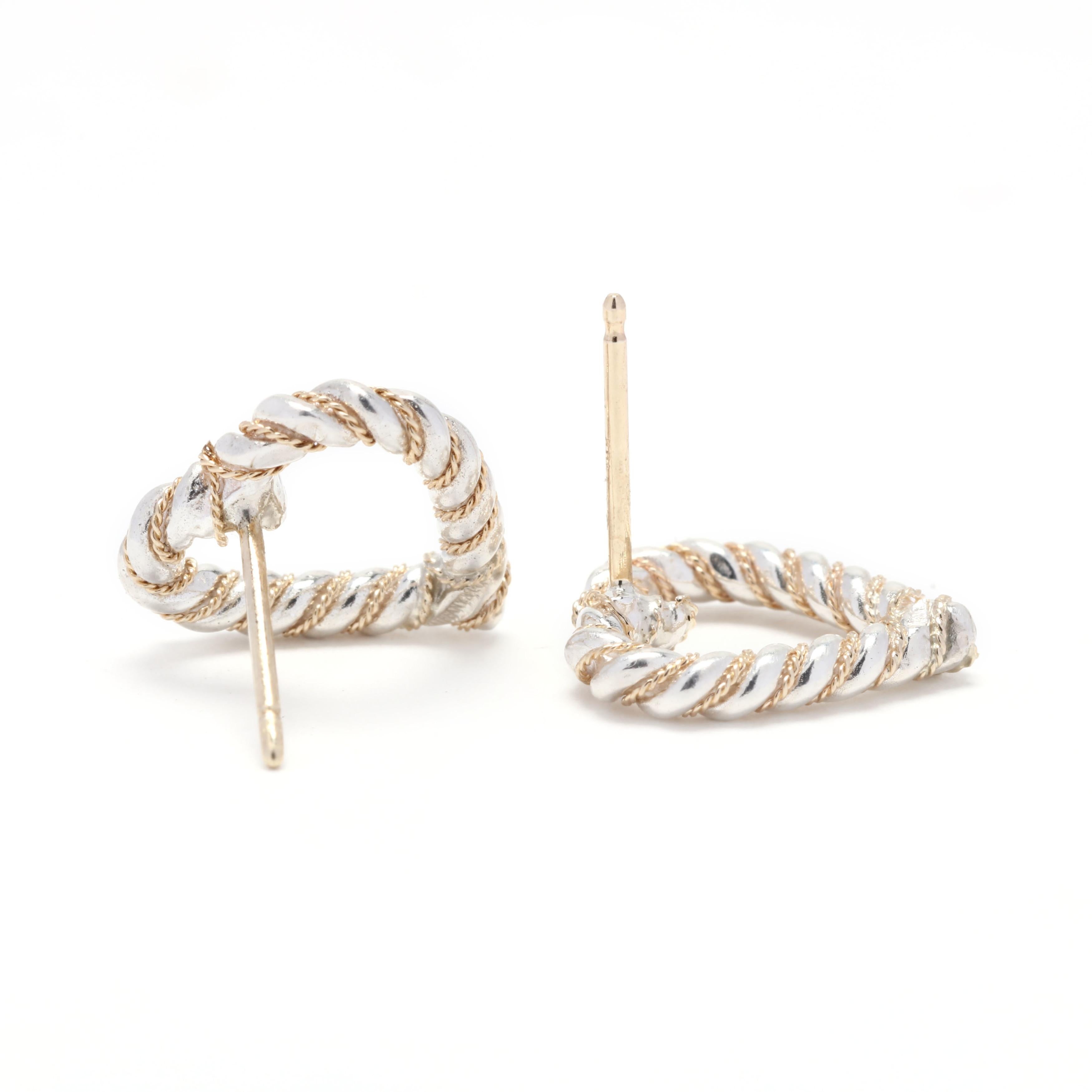 A pair of Tiffany and Company 18 karat yellow gold and sterling silver open heart rope stud earrings. These earrings feature an open heart design in a rope motif border and with pierced push backs. Please note that these earrings have replacement