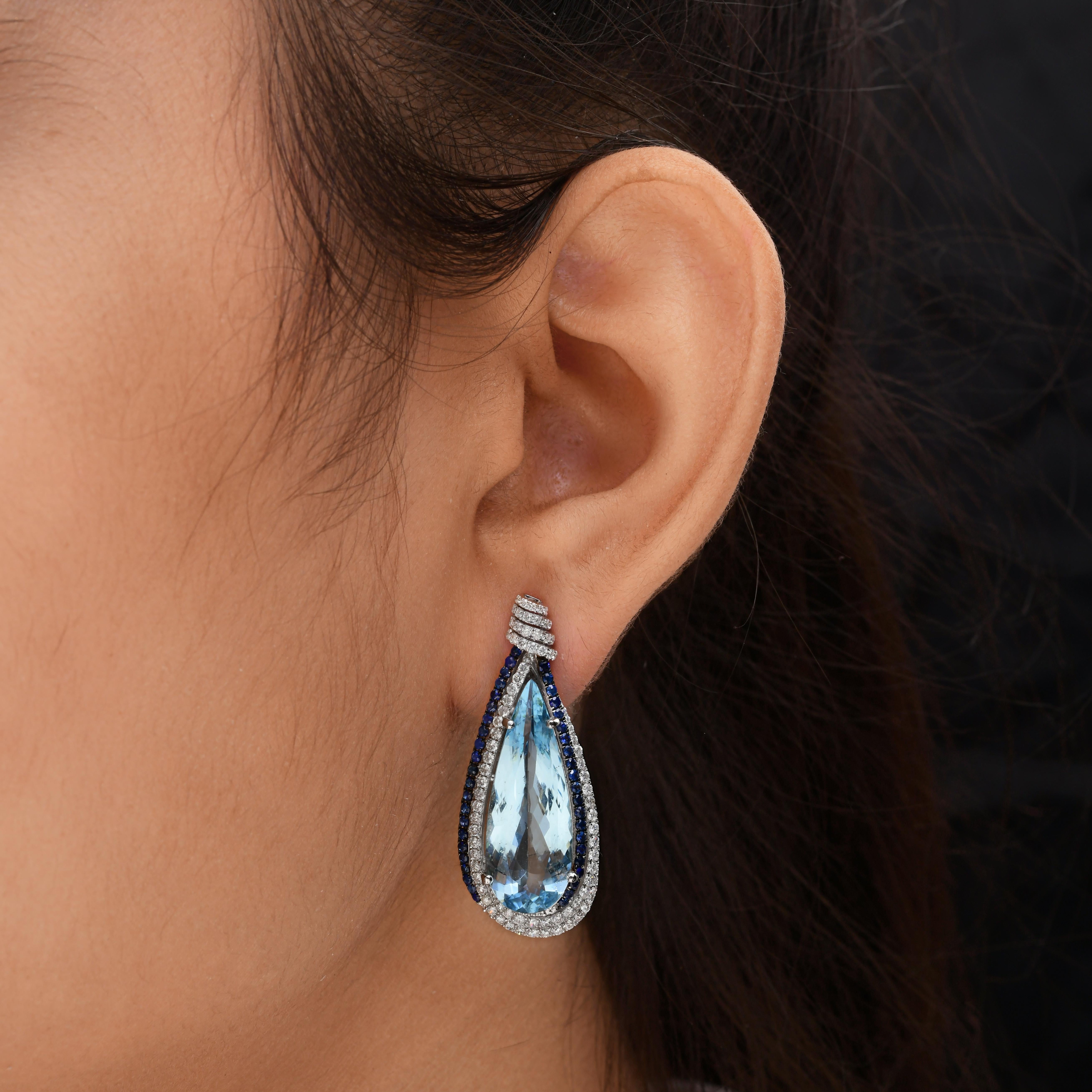 Boucles d'oreilles goutte d'aigue-marine et saphir en or blanc 14k Halo Diamonds TCW 17.11
Ces boucles d'oreilles sont centrées sur une grande pierre précieuse en forme de poire, l'aigue-marine. L'aigue-marine est entourée d'un double halo : une