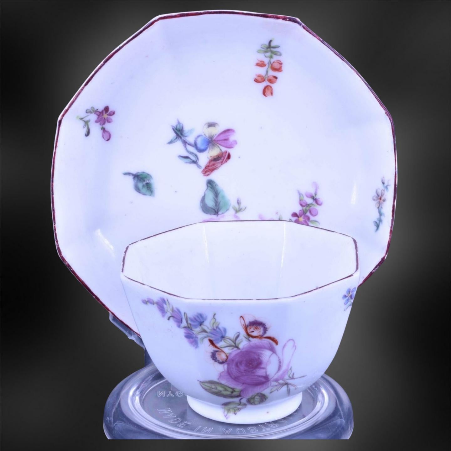 Un bol à thé octogonal et une soucoupe assortie, décorés des magnifiques peintures de fleurs habituelles de Chelsea. 

L'un des traits les plus distinctifs de la porcelaine de Chelsea est sa peinture florale complexe, qui présente souvent des