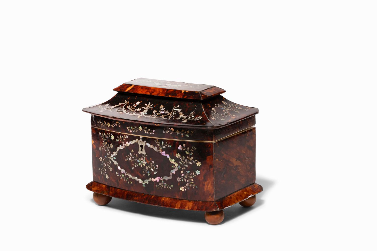 SALE ONE WEEK ONLY

Regency Mother-of-Pearl Inlaid Tortoiseshell Tea Caddy from the 1st quarter of the 19th century. It has a sarcophagus form with hinged cover opening to disclose two lidded compartments. The top and front are elaborately inlaid