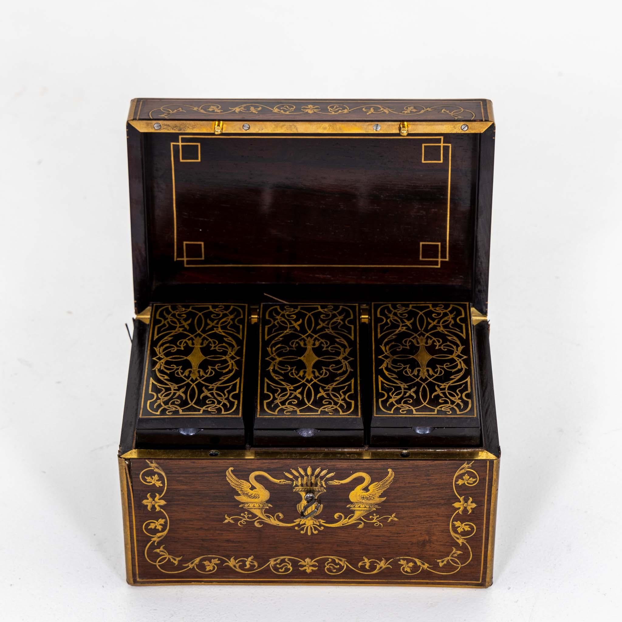 Small tea chest by Aucoc Paris made of mahogany with brass inlays in the form of swans and tendril motifs. The lockable box is equipped with three vessels inside, which also show brass inlays on the lids. Stamped 