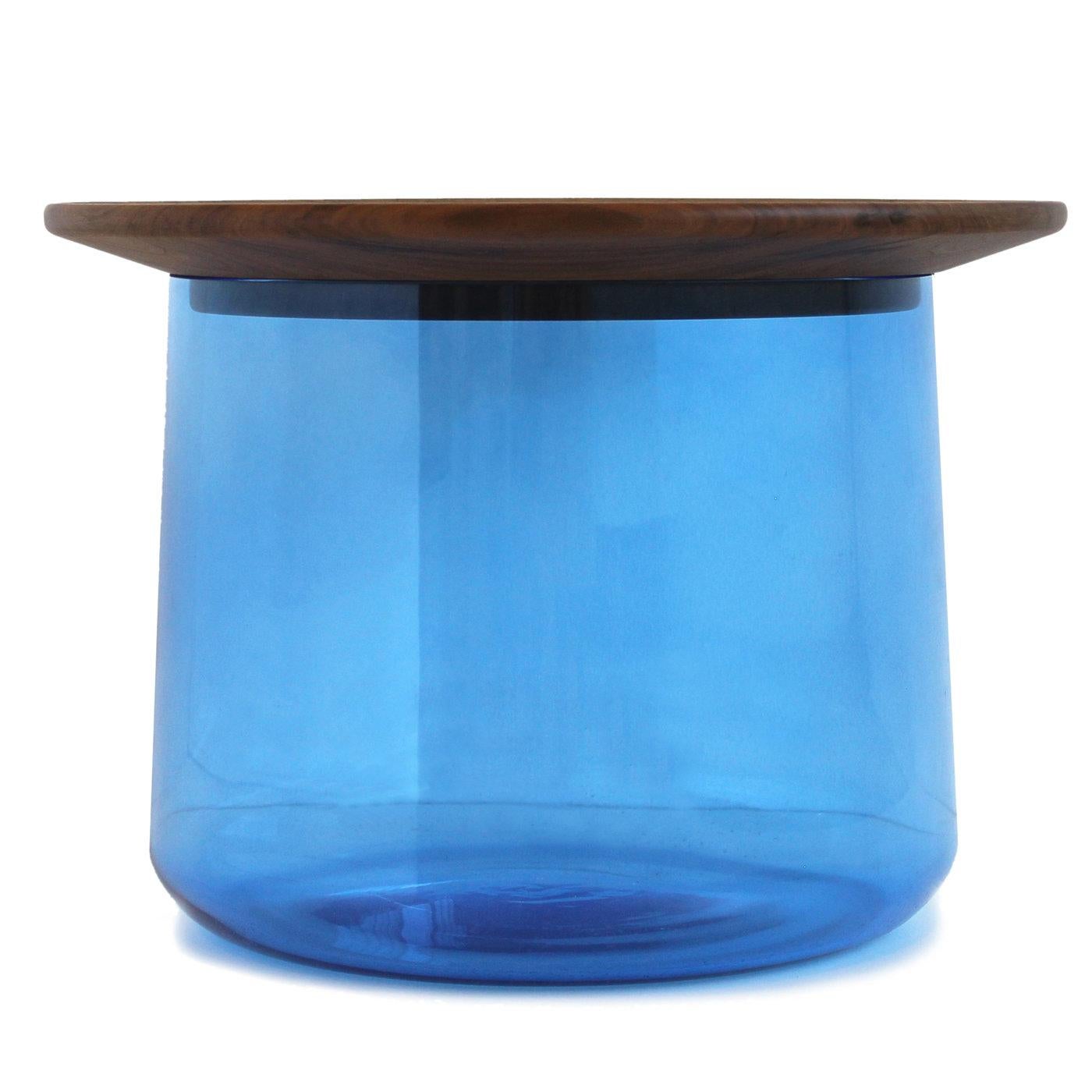 This striking coffee table is comprised of a large bottom vase in colored glass (that can function as container or storage space), and a top in solid 