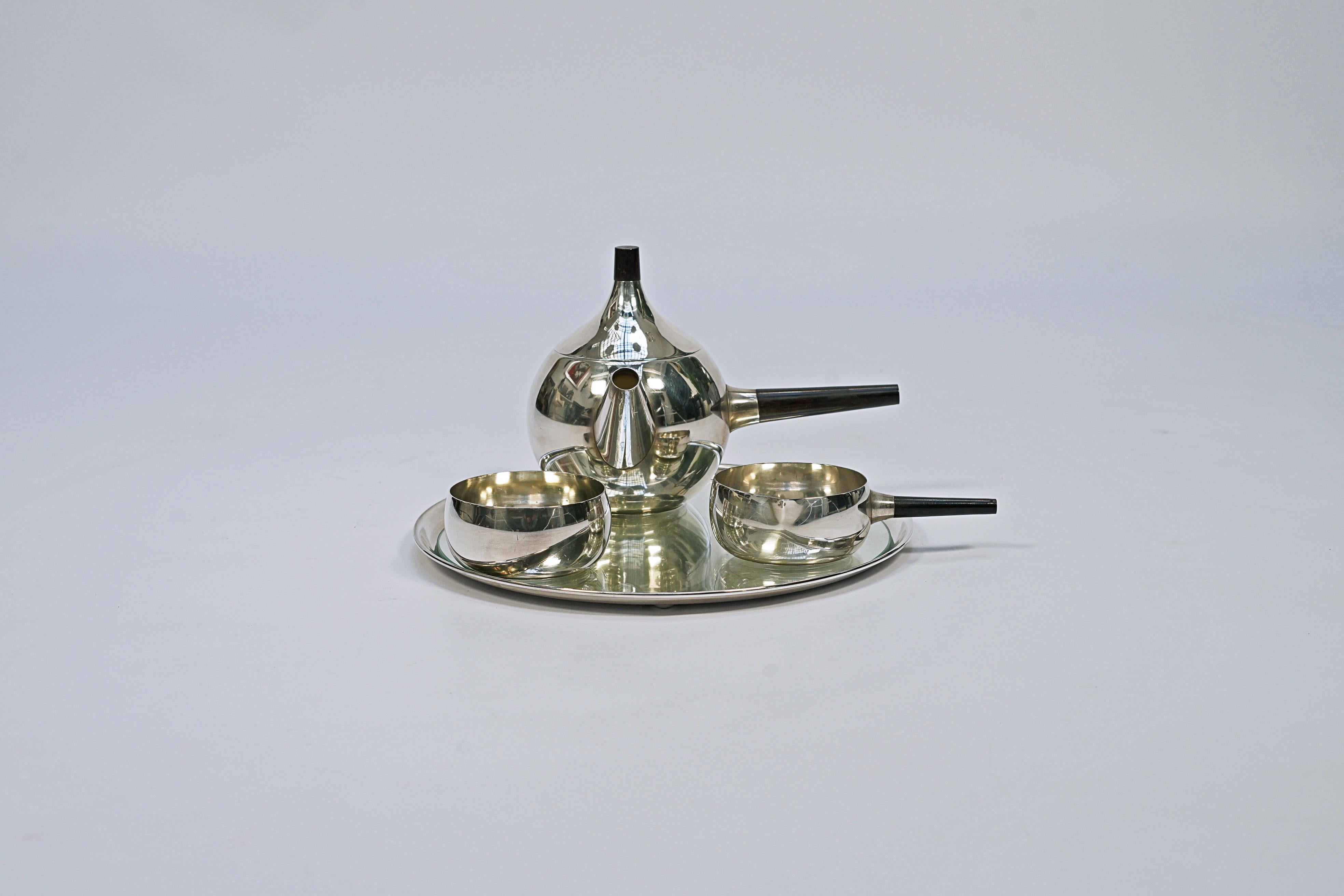 Tea set designed by Henning Koppel (1918-1981) and Georg Jensen (1866-1935). Four-piece silver tea set with a wooden handle, model No. 1091.

Signed Denmark, Georg Jensen Hallmark, Sterling, HK, A, 1091.

Denmark, CIRCA 1950.