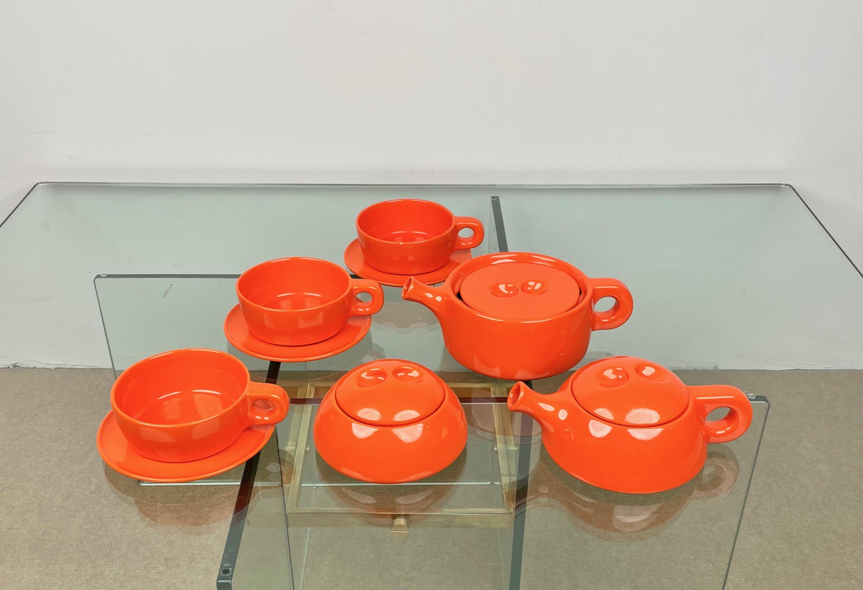 Stackable tea set in glazed orange ceramic, designed in the 1960s by the Finnish designer Liisi Beckmann for Gabbianelli. 

Consisting of: 2 teapots, 3 tea cups and a sugar bowl. 

The original label is still attached on the bottom, as shown in