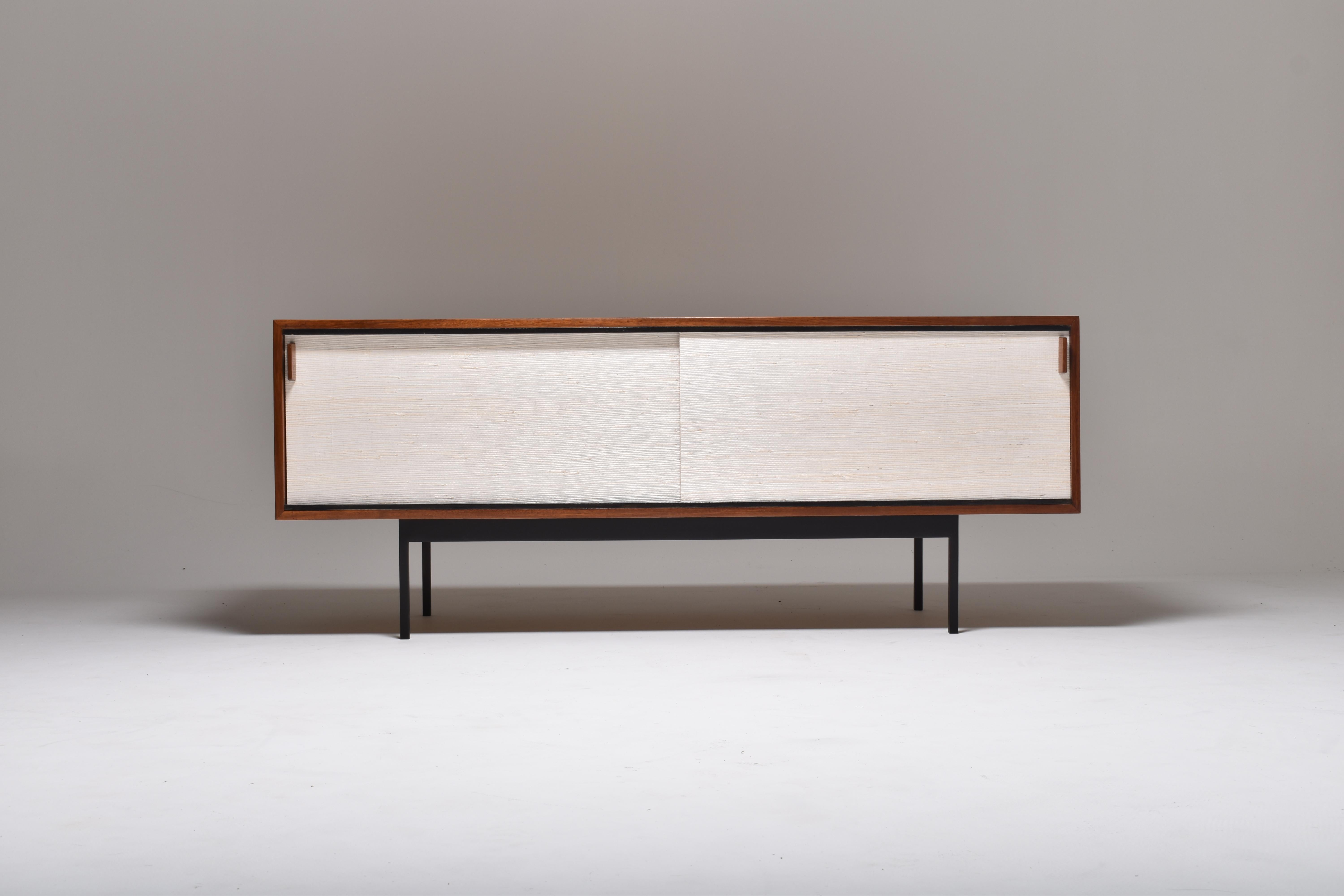 Teak sliding doors sideboard by Dieter Waeckerlin.

The sideboard is part of a furniture series designed at the end of the 1950s by Swiss designer and interior designer Dieter Waeckerlin and produced by his own furniture manufacturer Idealheim, in