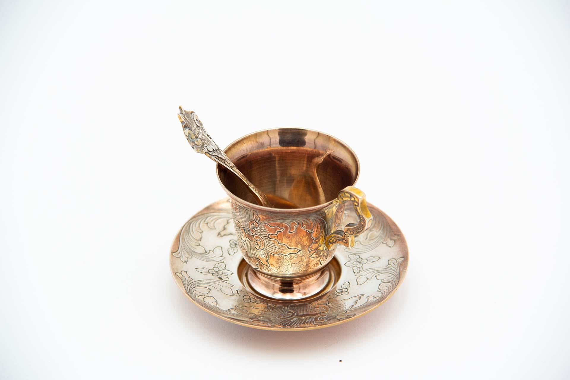 Description : Tasse à thé avec soucoupe et cuillère en argent doré avec motifs végétaux gravés. Métal : Argent. Origine : Portugais. Marque : Cabeça de escravo. Poids : 147,93 grammes. Dimensions : sur demande. Contenu : 833/1000. Marque d'essai :