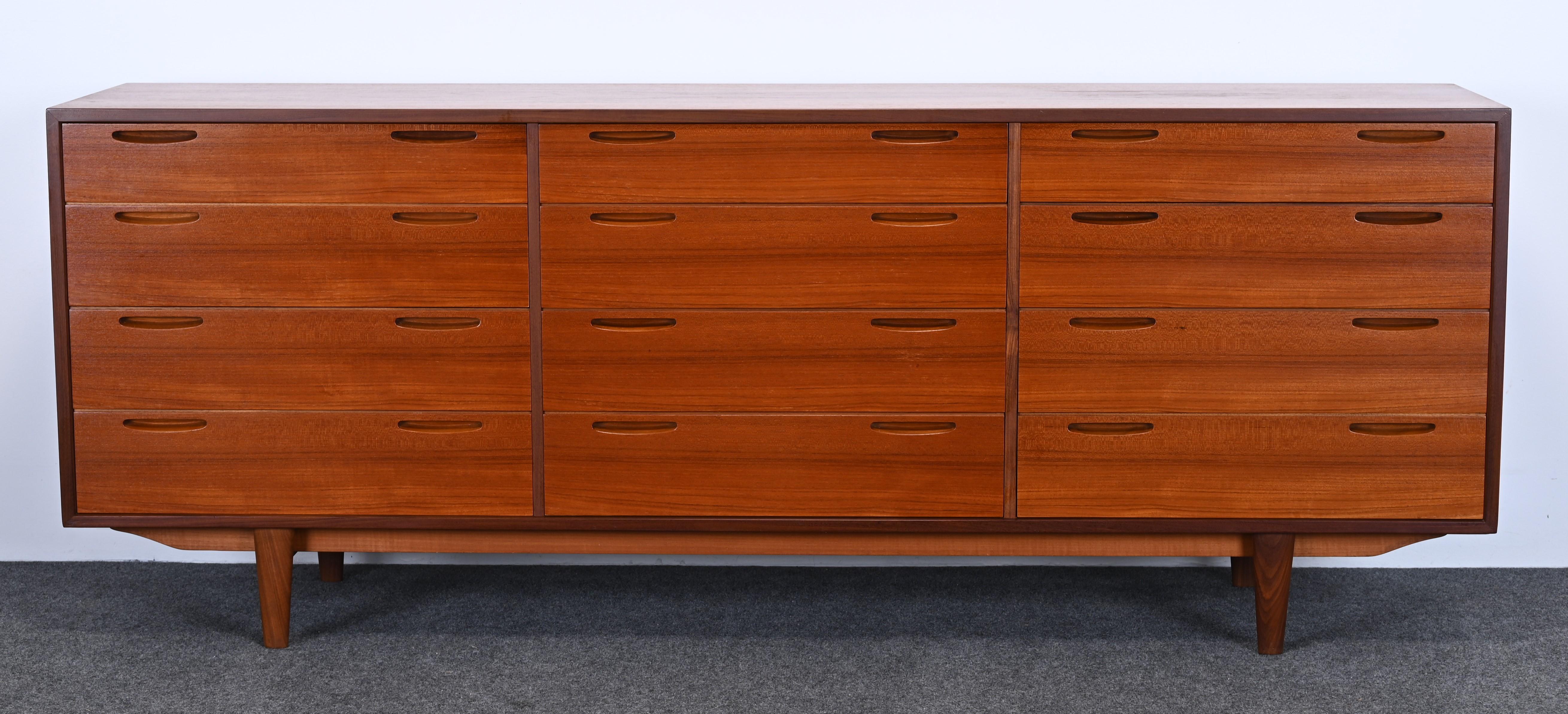 A sleek Mid-Century Modern 12 drawer dresser by Ib Kofod-Larsen. This amazing chest of drawers has style and function. The top surface has been refinished and the base has been top coated. The interior of the drawers is very clean. Slight shadow on