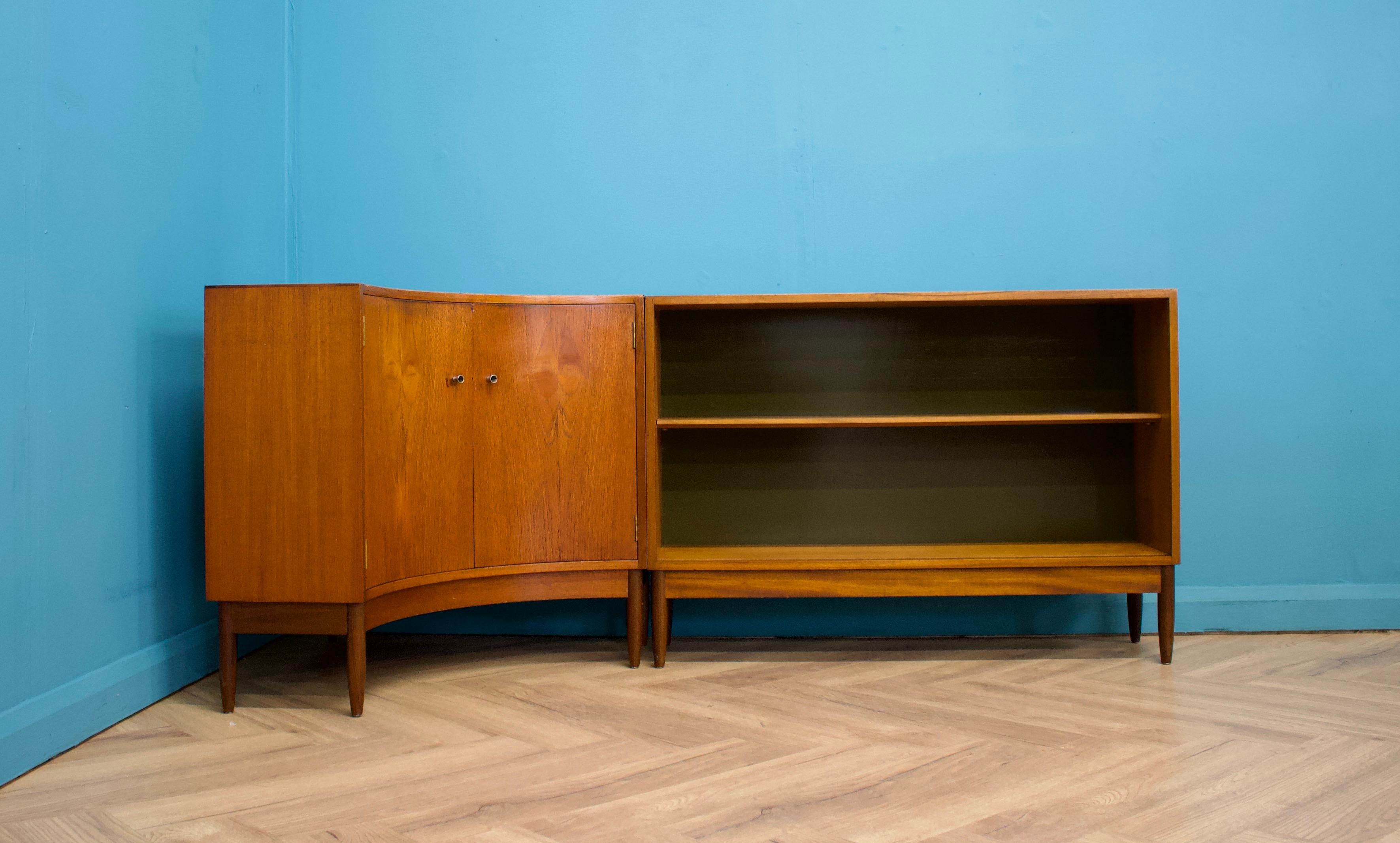 A mid century two piece teak corner cabinet and bookcase from Greaves & Thomas, circa 1960s




The corner cabinet features a curved front and shelving inside

The bookcase originally had glass sliding doors, which are not present now




This would