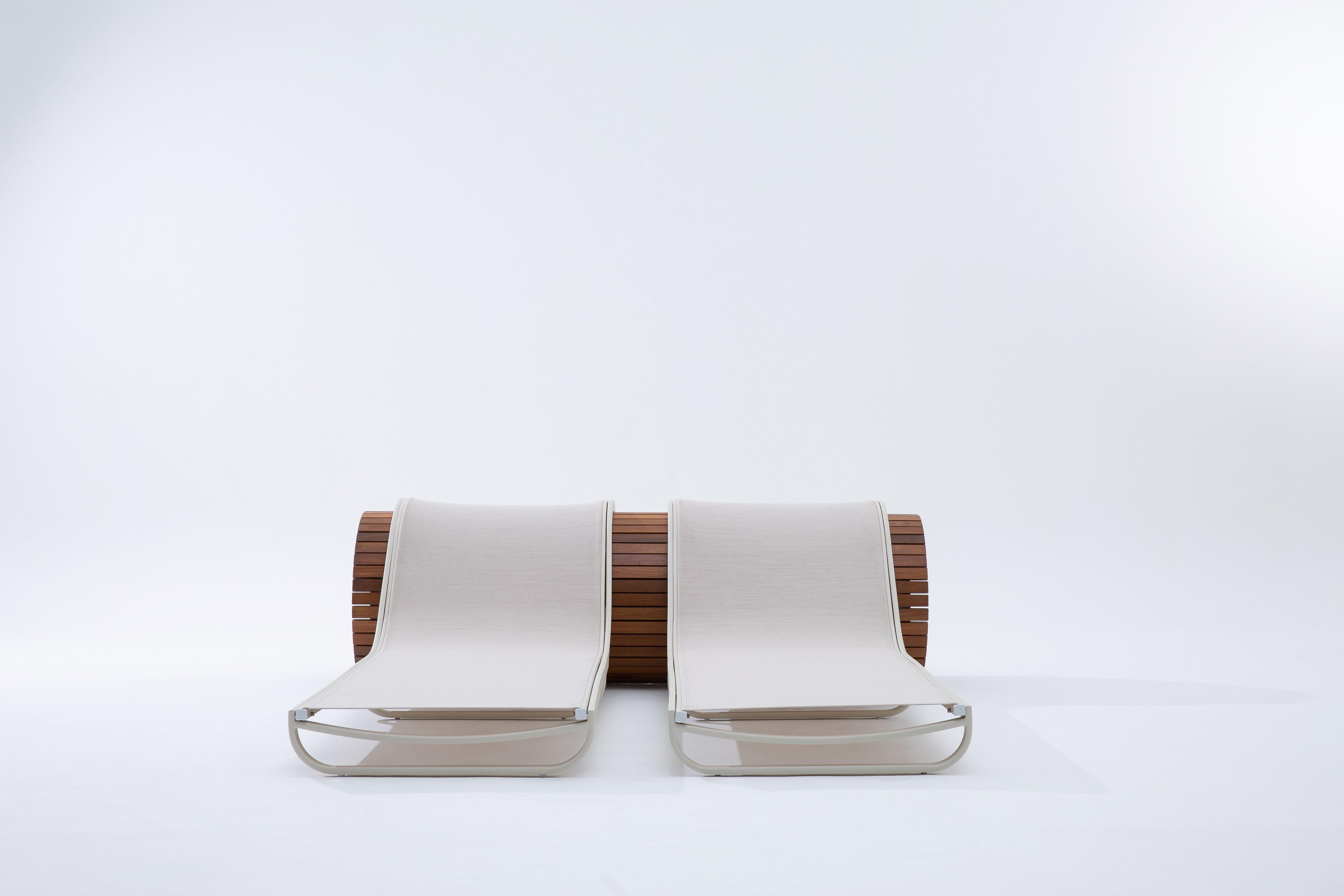Designed by Roberta Banqueri exclusively for +55design, the sleek Zero chaise sun lounger is a sculptural piece crafted from premium teak and powder-coated aluminum. Its sleek form extends lightly beyond the wooden cylindrical structural frame,