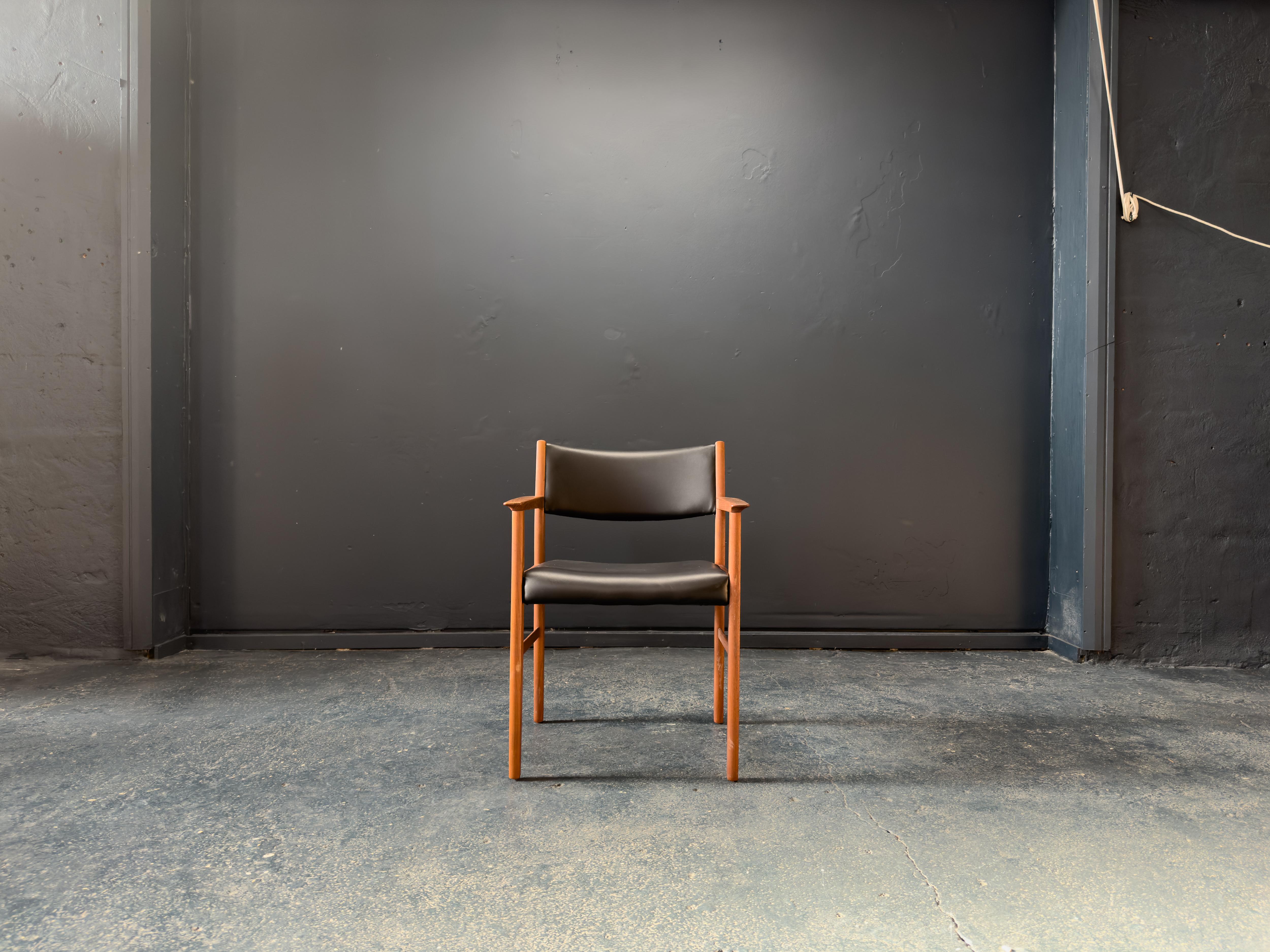 Questa elegante poltrona di metà secolo combina il calore del teak massiccio con la raffinatezza senza tempo del rivestimento in pelle nera. Con le sue linee pulite, le proporzioni equilibrate e i dettagli curati, la sedia offre un fascino visivo e