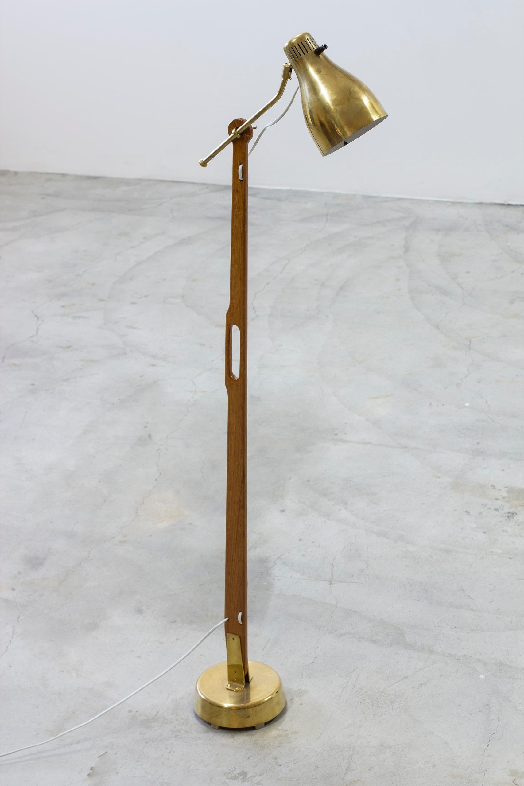 Floor lamp model 544 designed by Hans Bergström. Made from brass and solid mahogany. Adjustable shade in brass with white lacquered inside. Turning light switch in bakelite on the shade, in working order. Very good vintage condition with light age