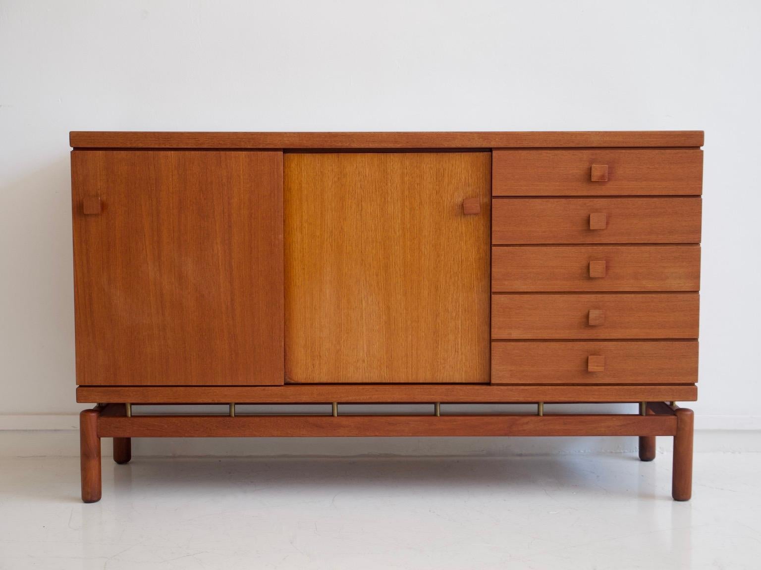 Credenza in legno di teak con ante scorrevoli e cinque cassetti, dettagli in ottone. Prodotto in Italia da La Permanente Mobili Cantù negli anni '60.