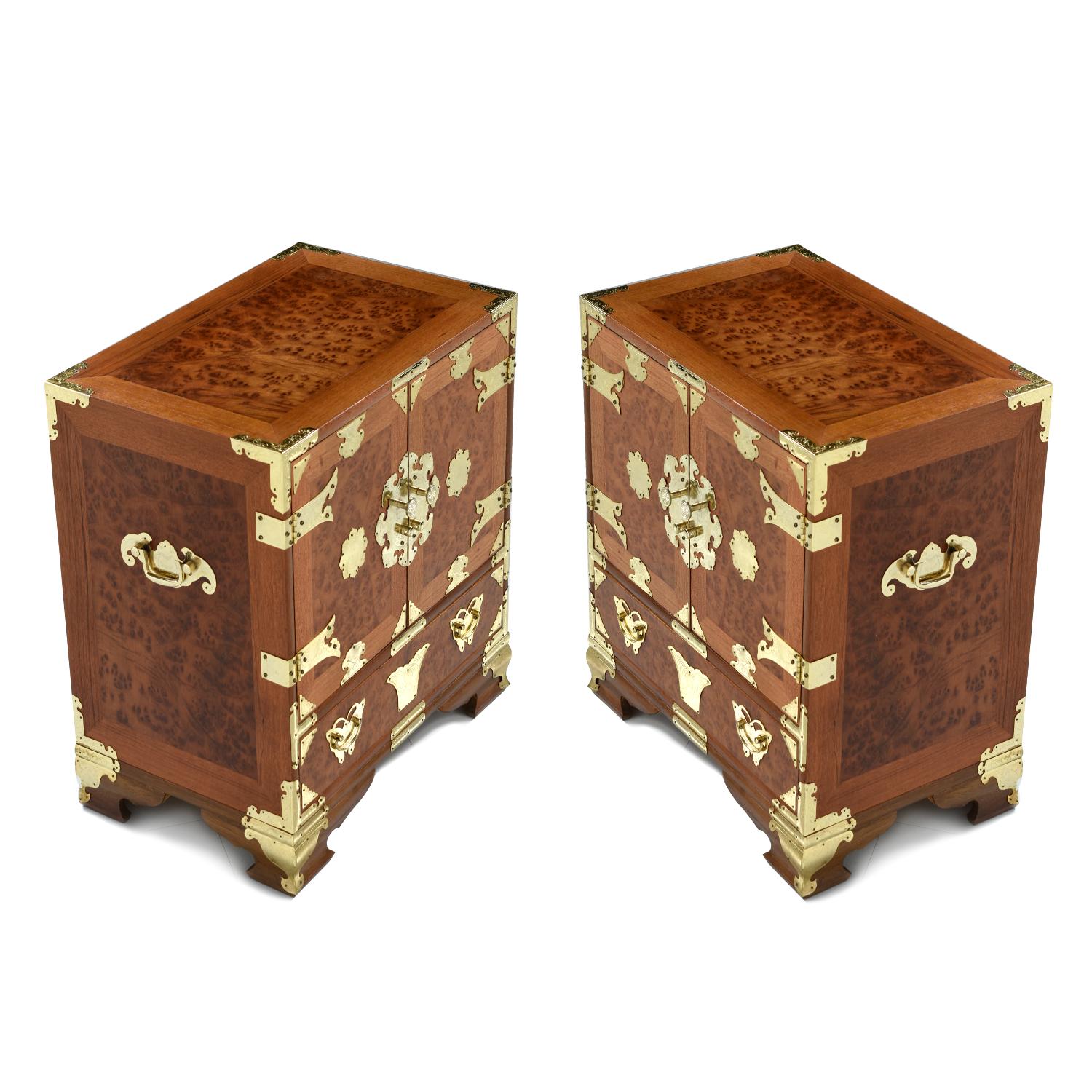 This pair of vintage Campaign style Chinese influence nightstands are absolutely decadent. Crafted from the best of the best, teak and burl woods, and embellished with glittering brass fittings. These cabinets command attention. We are calling these