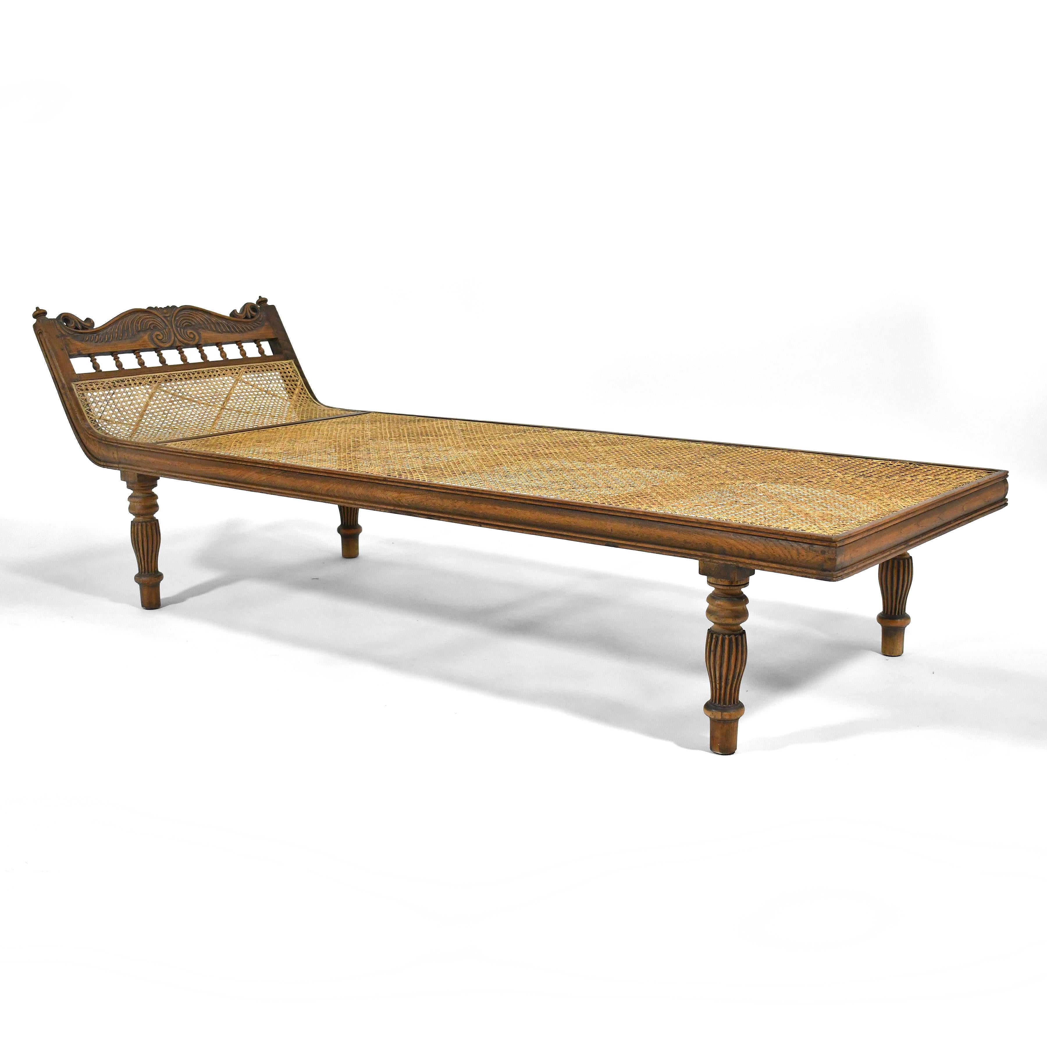 This striking chaise is long, lean and luxurious. A teak frame with lovely carved details and a woven cane support offers a platform for lounging, reading and relaxing. Made more comfortable by a beautiful woven quilted pad and pillow.

This