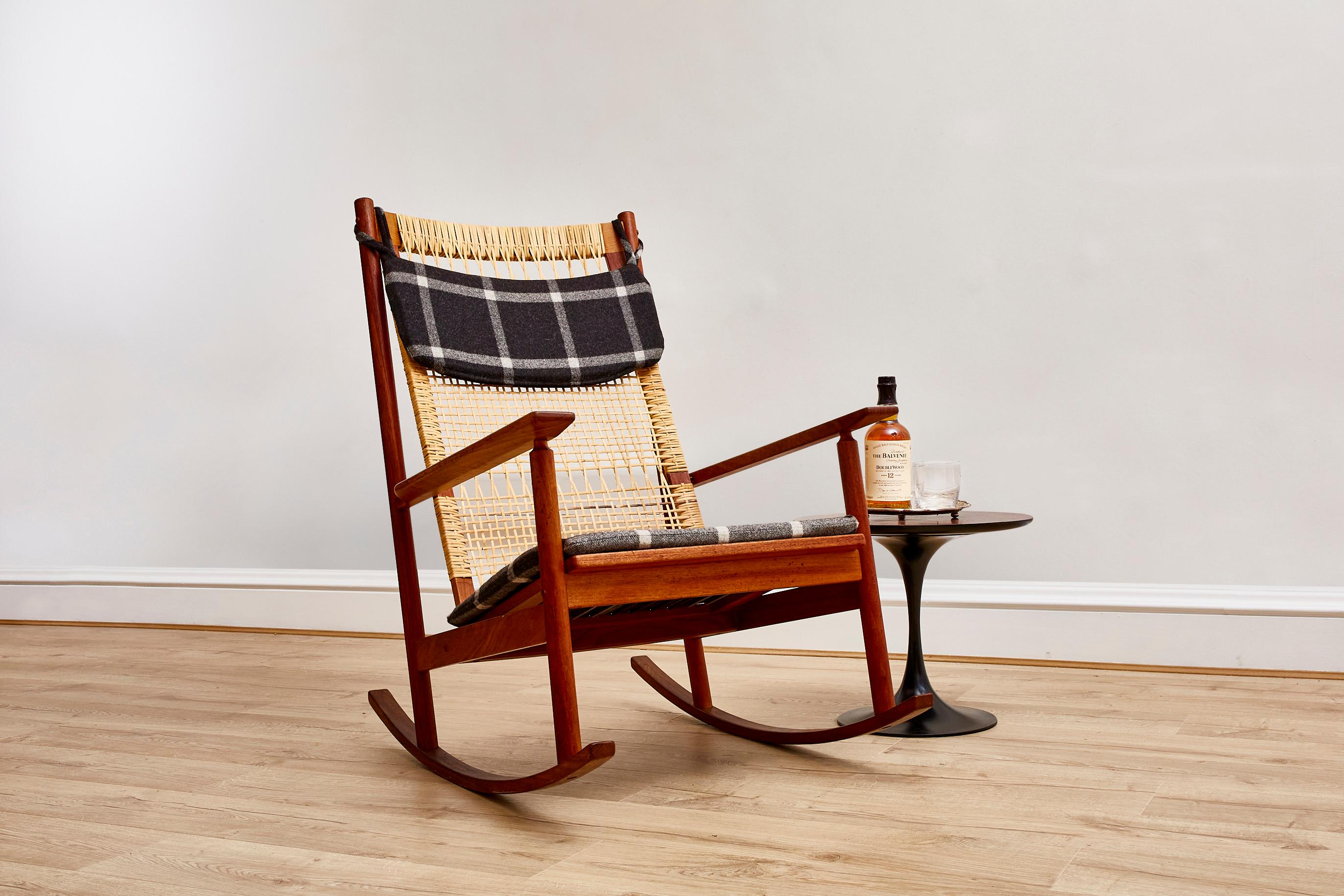 Experience the captivating allure of mid-century Danish design with this remarkable Teak and Cane Rocking Chair crafted by the acclaimed designer Hans Olsen for JK Denmark. Dating back to the 1950s, this chair embodies the essence of an era known