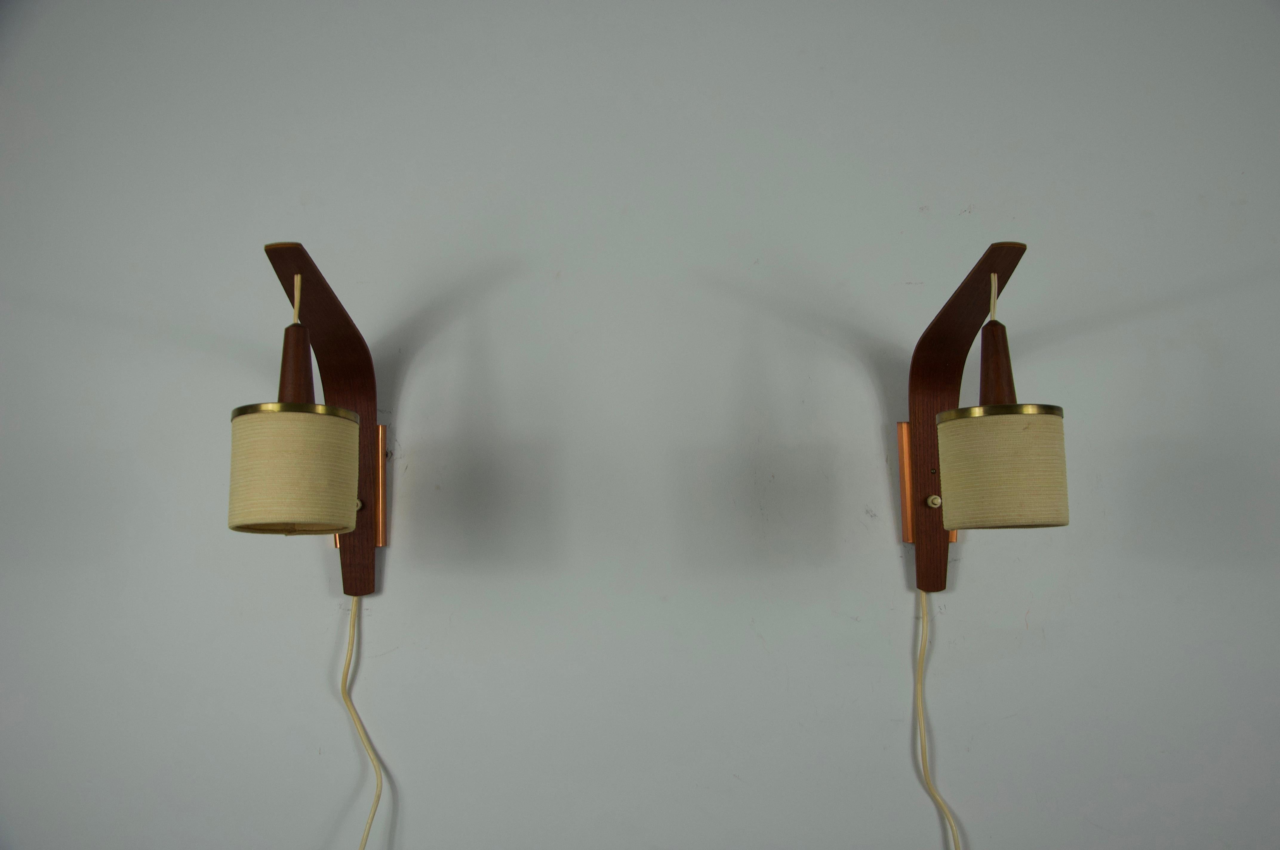 Queste eleganti lampade da parete tedesche, realizzate negli anni '60, incarnano il fascino senza tempo del design moderno di metà secolo. Ogni pezzo è caratterizzato da un braccio in legno di teak splendidamente curvato che si estende con grazia