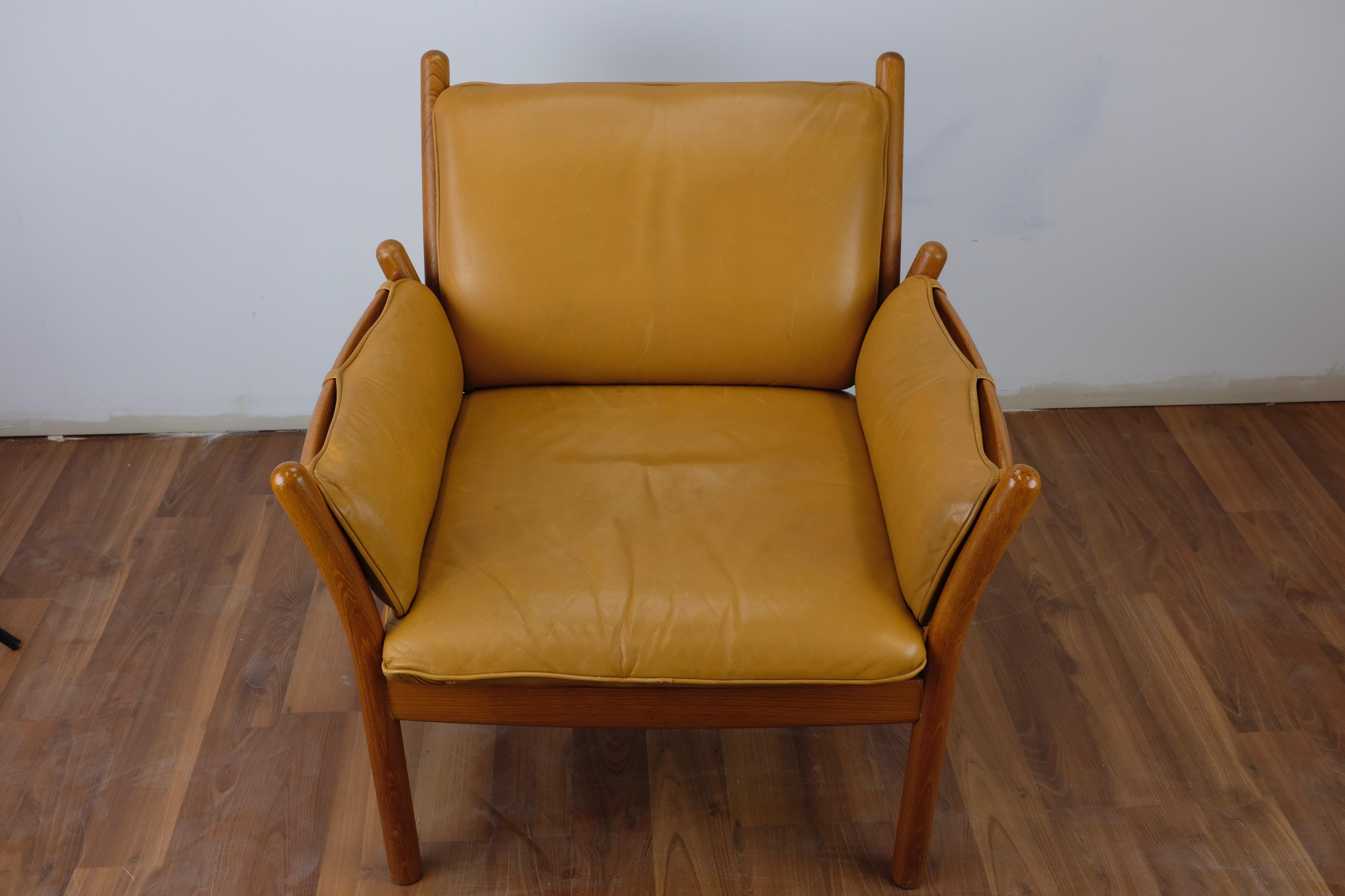 One 'Genius' armchair designed by Illum Wikkelø and made in Denmark by CFC Silkeborg.

The frame is constructed of solid teak. The cognac leather seat cushion is loose while back and arm cushions are secured to the frame with straps and can be