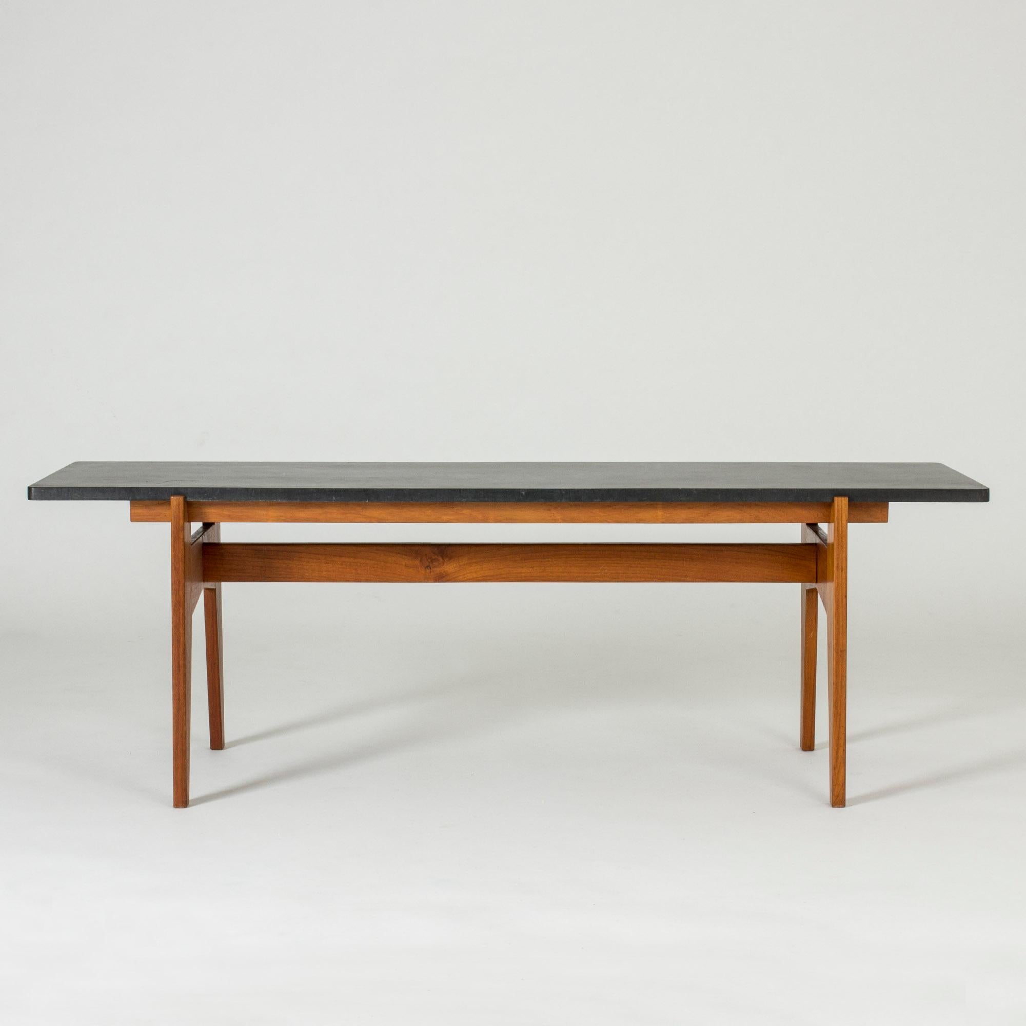 Teak and black stone coffee table by Hans-Agne Jakobsson, made in the early 1950s in his Åhus studio. Very cool, strict Silhouette, some structure in the table top.