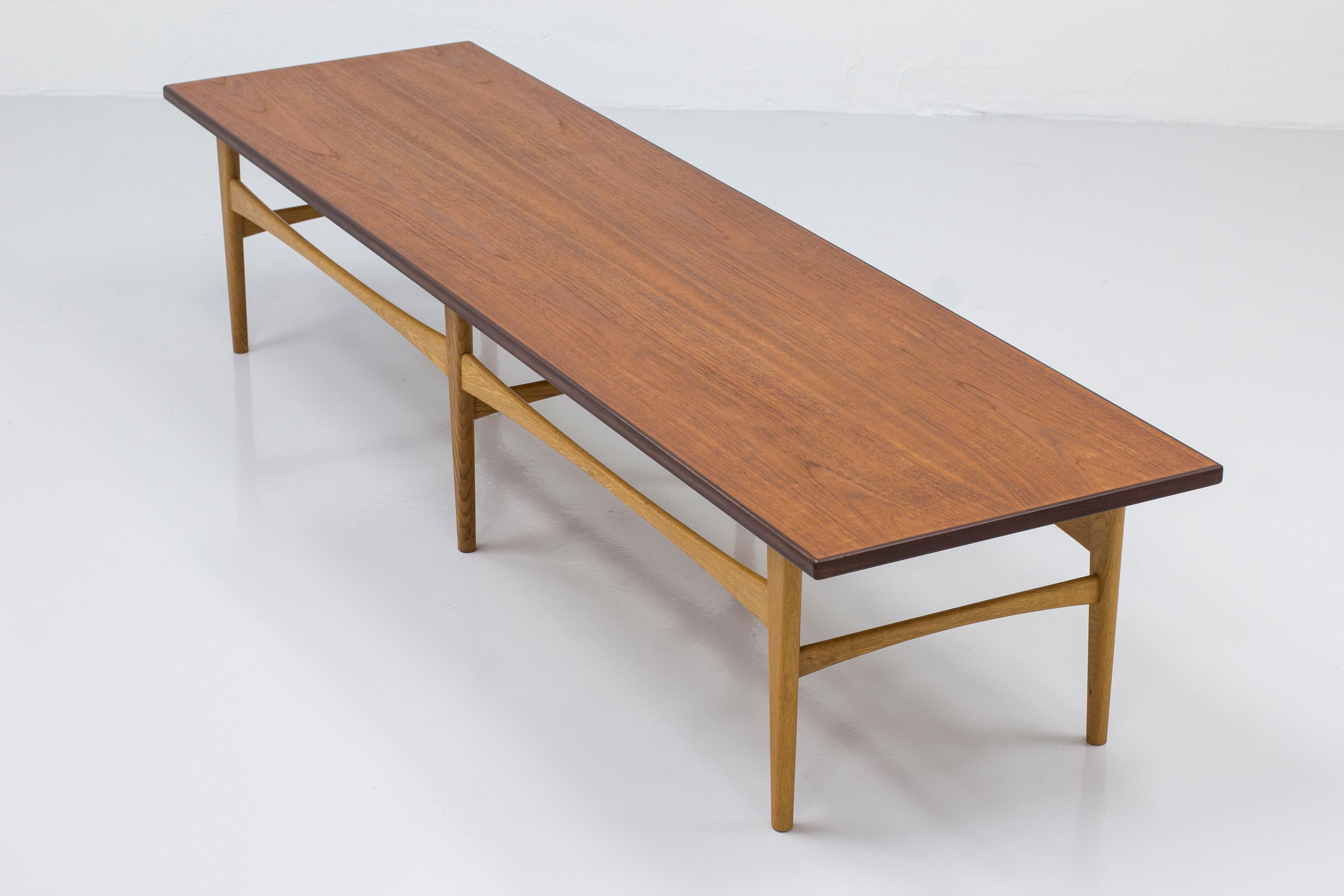 Banc ou table de canapé conçu par Eric Johansson. Produit par Abra möbler en Suède dans les années 1950. Fabriqué en chêne massif pour la base et en teck pour le plateau. Très bon état vintage avec quelques traces d'usure et de patine liées à