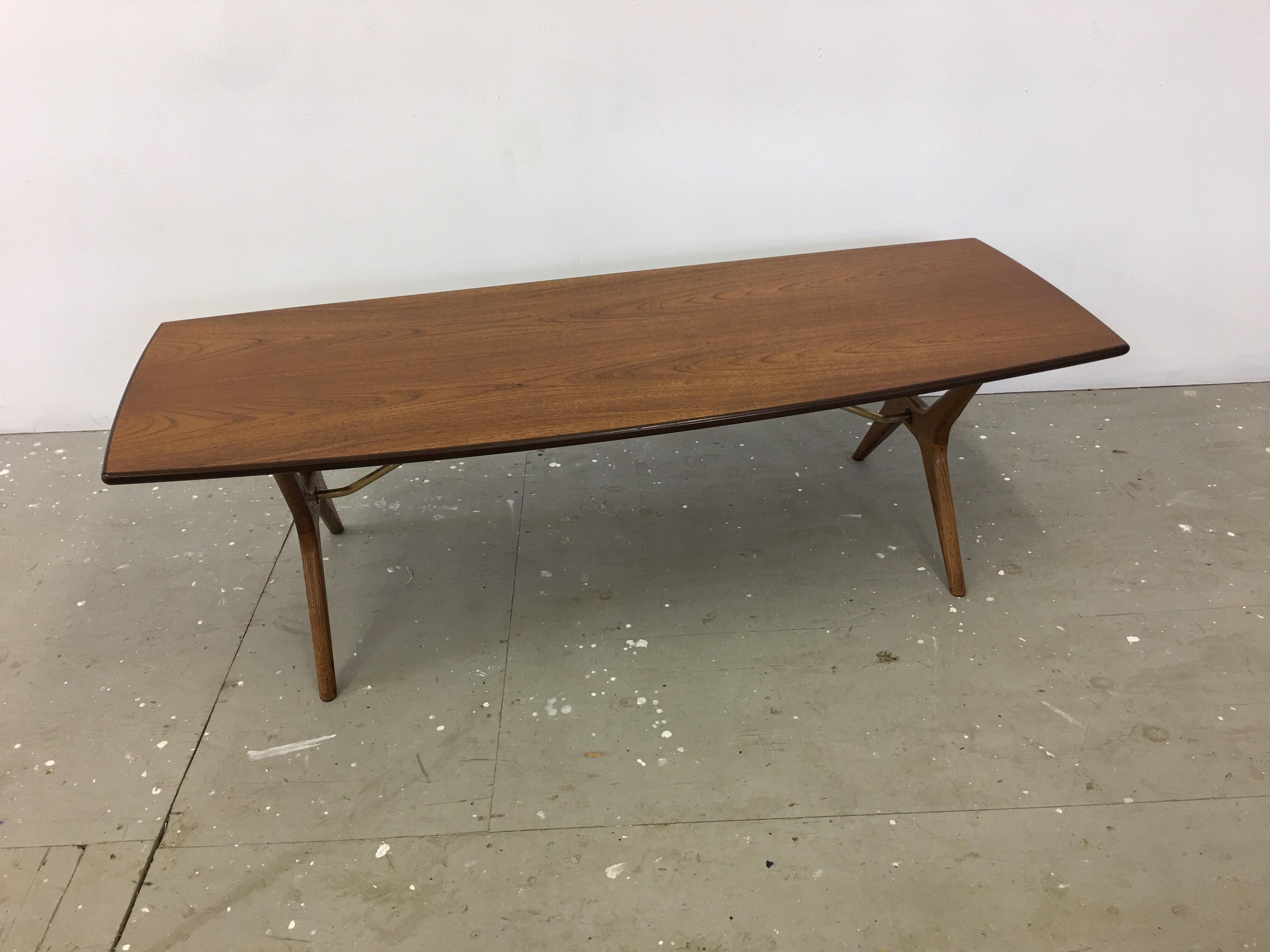 Karl-Erik Ekselius for JOC Vetlanda teak, oak and brass coffee table. Slight boat shaped design top with solid oak X-base legs. Each leg has a brass support that attaches to underside of table and goes through leg with an oversized brass screw.