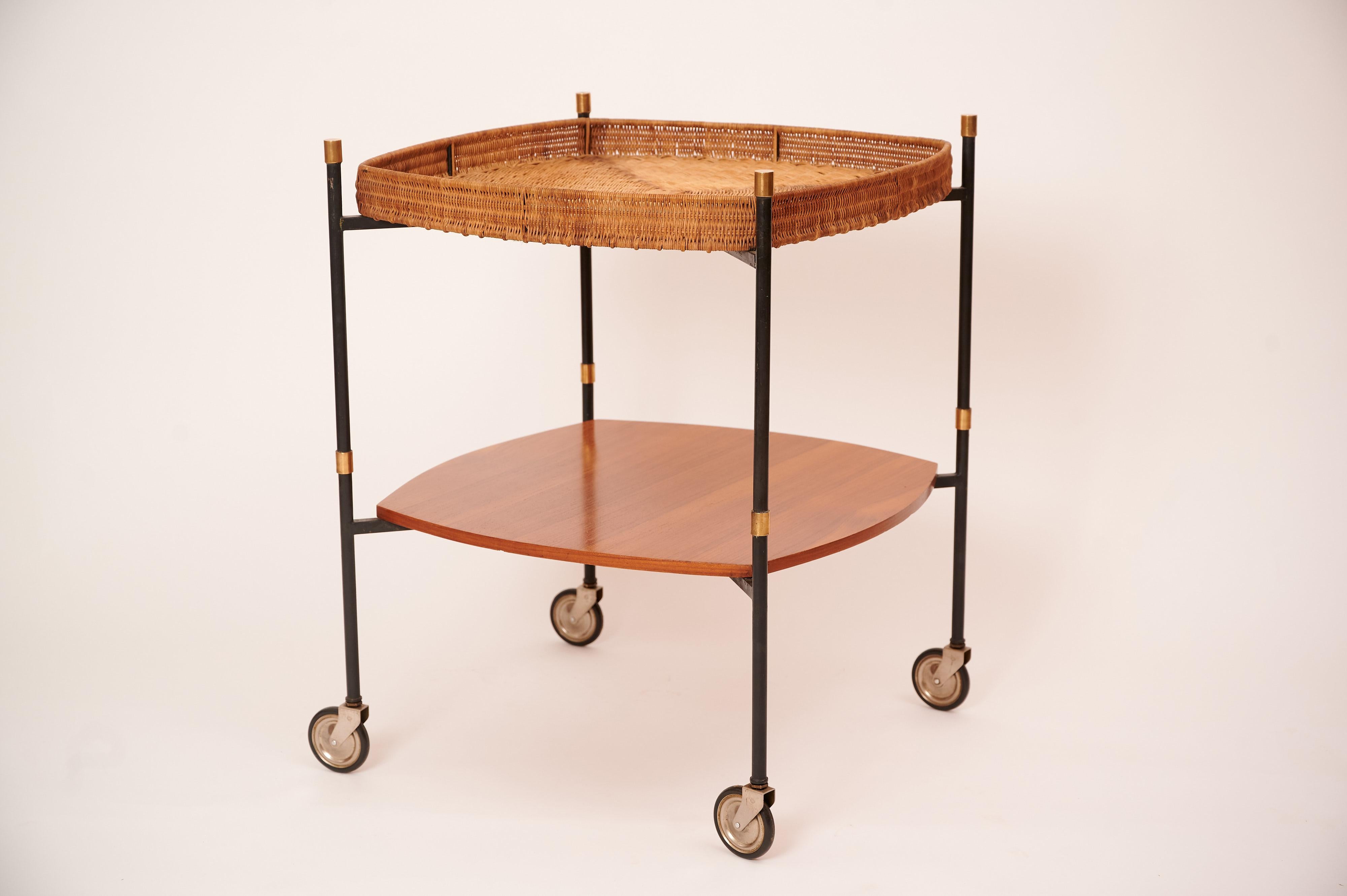 A rare teak and rattan drinks or serving cart. 

The rattan tray at the top detaches, and can be used as a bed tray. (See images.)

The trolley has been restored and is in good working order. 

Rattan, teak with brass accents. 

