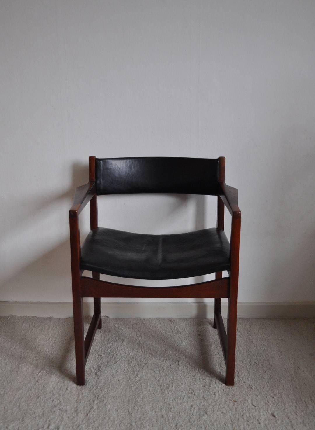 Armchair model 370 designed by Peter Hvidt & Orla Mølgaard-Nielsen made of solid teak wood, armrest inlaid with rosewood, seat and headpiece upholstered with black leather. Manufactured by Søborg Møbler, 1959. Age-related traces of use, leather with