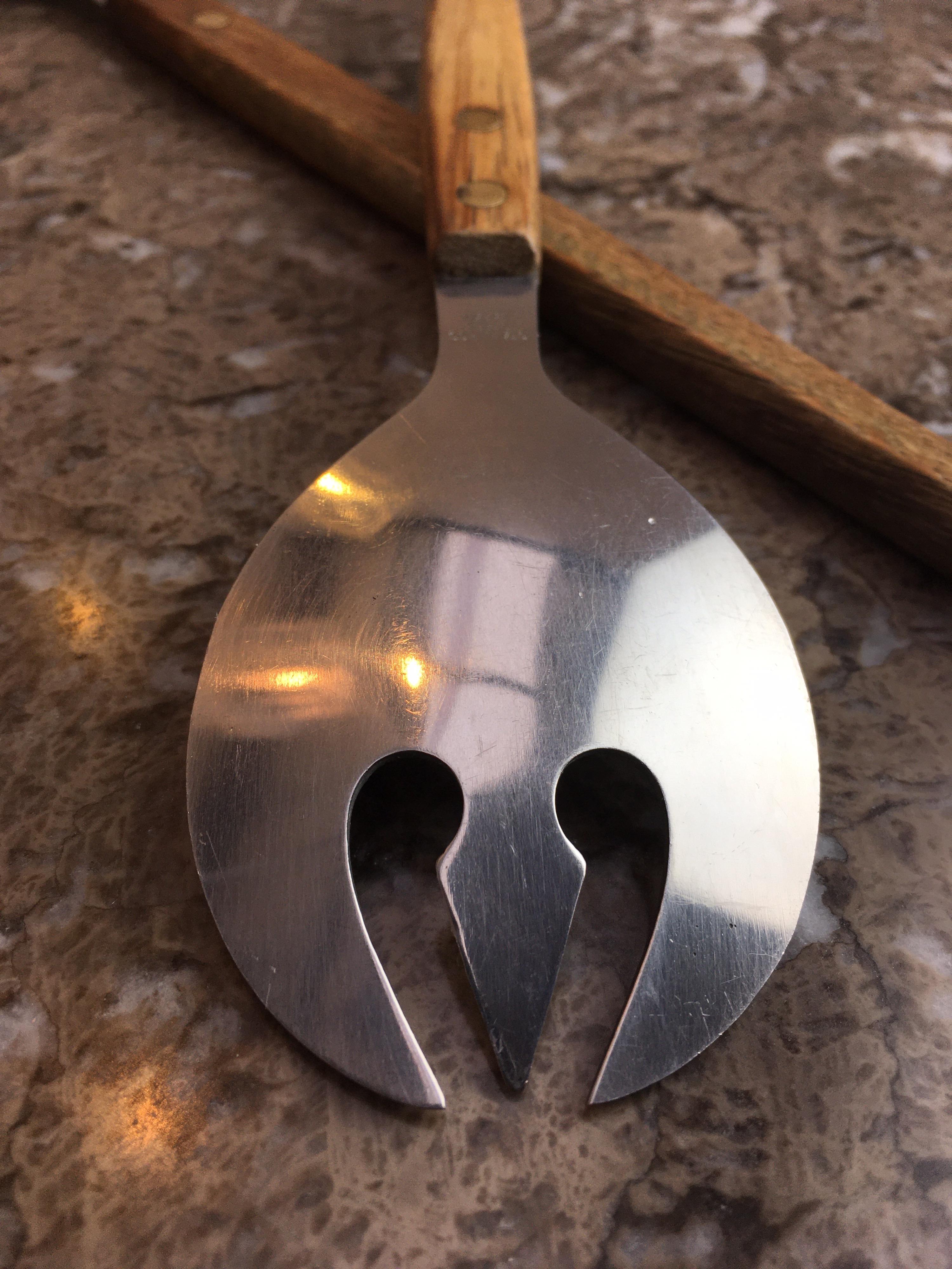 A tidy pair of salad servers with long handles made of teak. Polished brass studs show through for added character.

We love these for their honesty and simplicity and for the fanciful little ‘Neptune’s trident’ shape in the salad fork. 

Expect