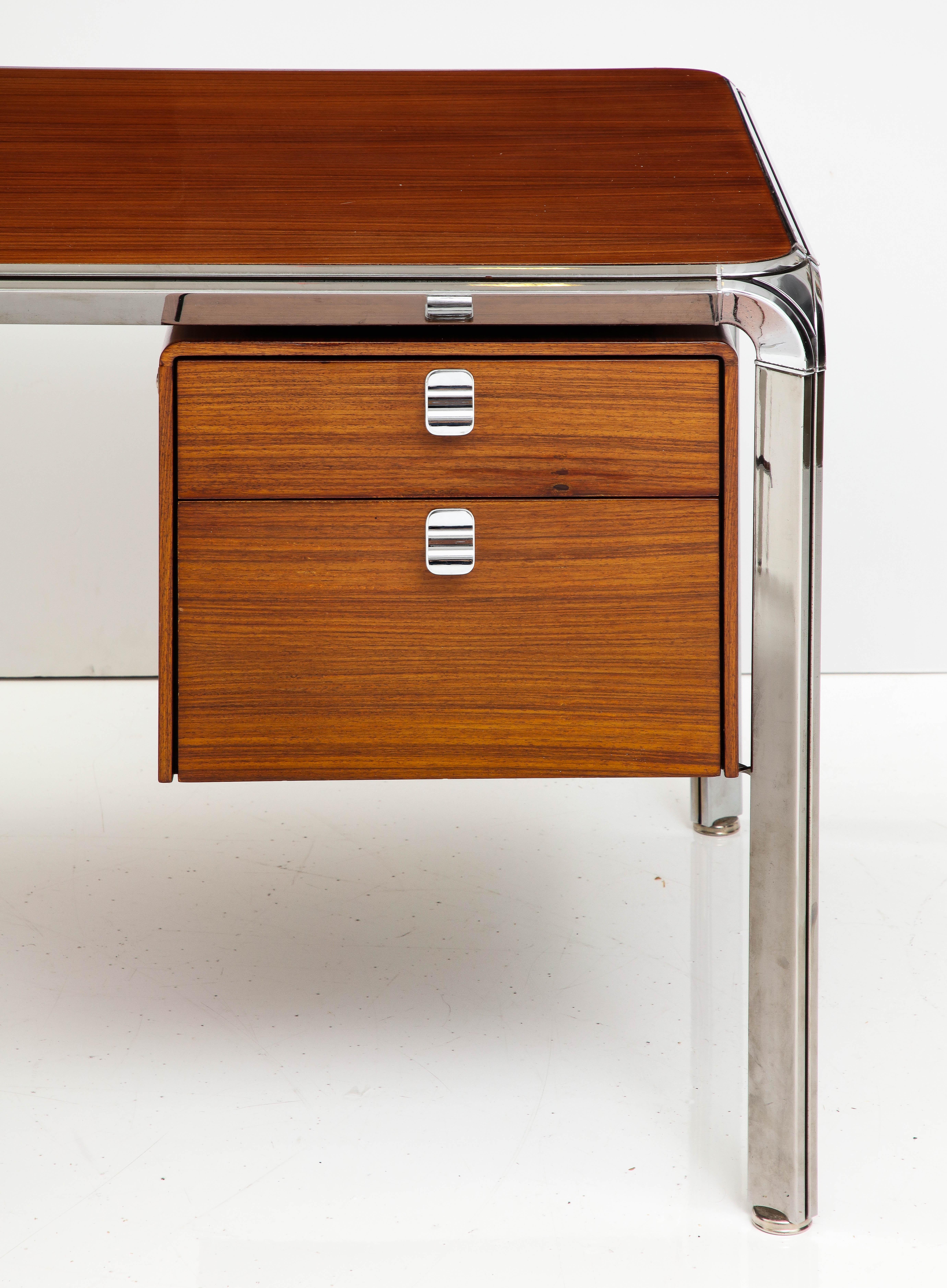 Teak and steel executive desk by Pierre Paulin, France, c. 1975. 

Sleek executive desk (model no. 250) in Burmese teak and polished stainless steel by esteemed French designer Pierre Paulin. Manufactured by Dassas, this desk is in excellent
