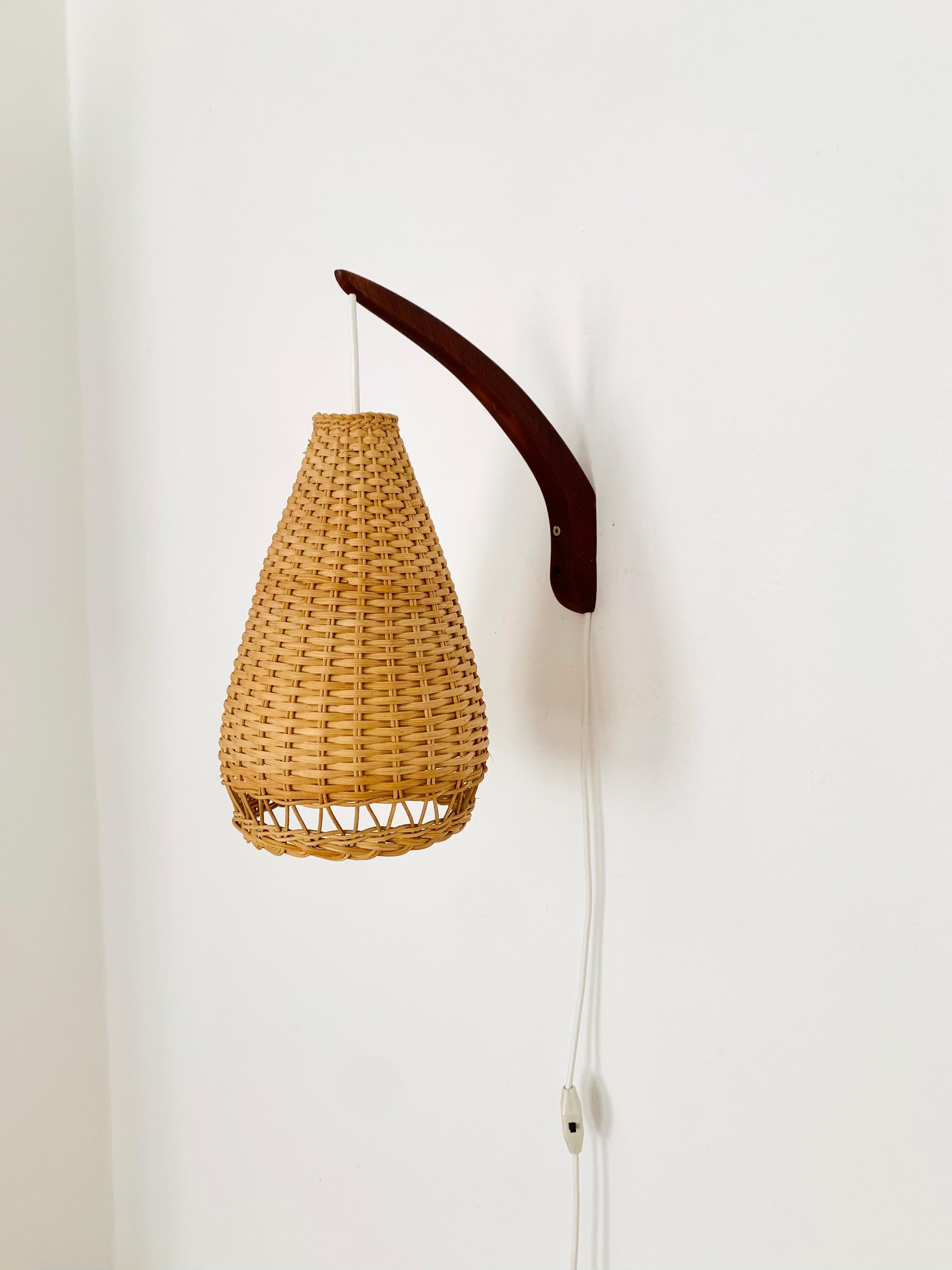 Wonderful Danish teak wall lamp from the 1960s.
Great and unusual design with a fantastically elegant appearance.
The rattan lampshade creates a very cozy atmosphere and a spectacular play of light.

Condition:

Very good vintage condition with