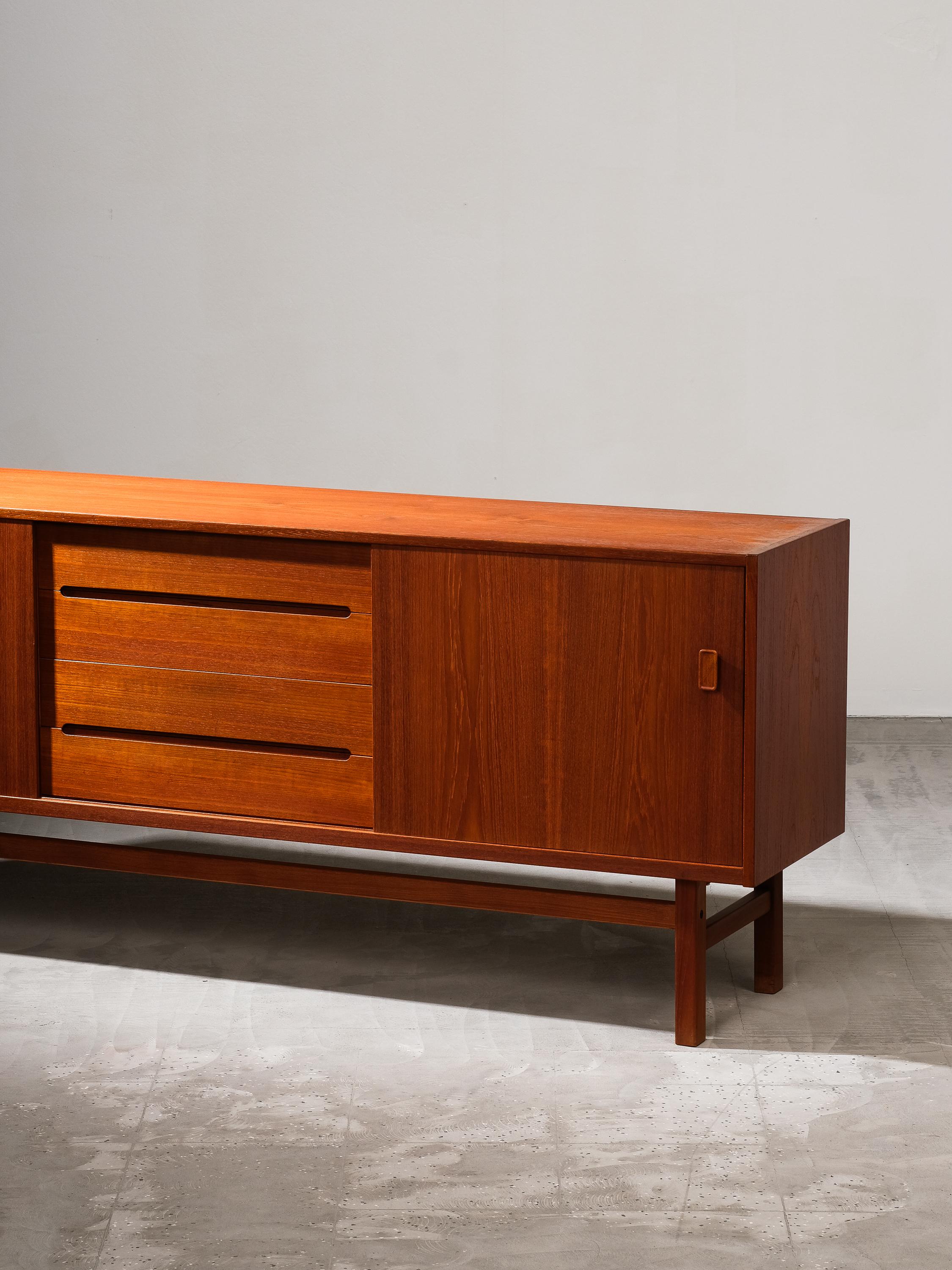 Discover the exquisite craftsmanship of this unique Nils Jonsson teakwood sideboard model 'Arild', boasting a distinctive Scandinavian Modern style. Crafted with precision and elegance, it features two sliding doors on both sides, adorned with two