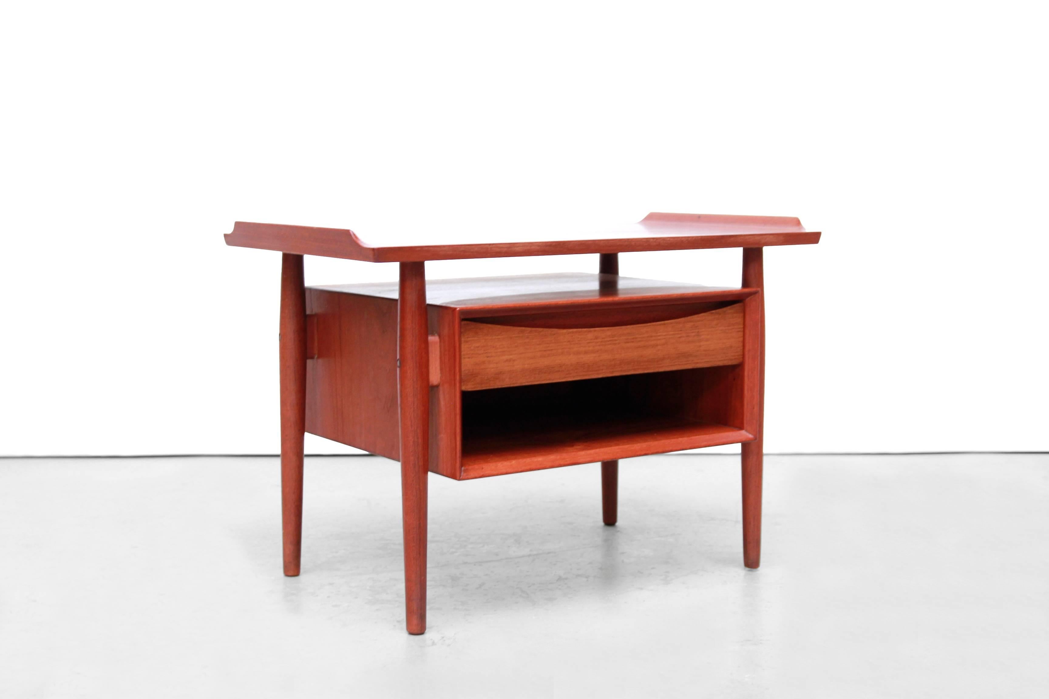 Beautiful side table with iconic drawer designed by famous Danish designer Arne Vodder for Sibast Mobler Denmark in the 1950s. This table with storage space can also be used as a hallway table with a mirror above or as a bedside table. This piece of