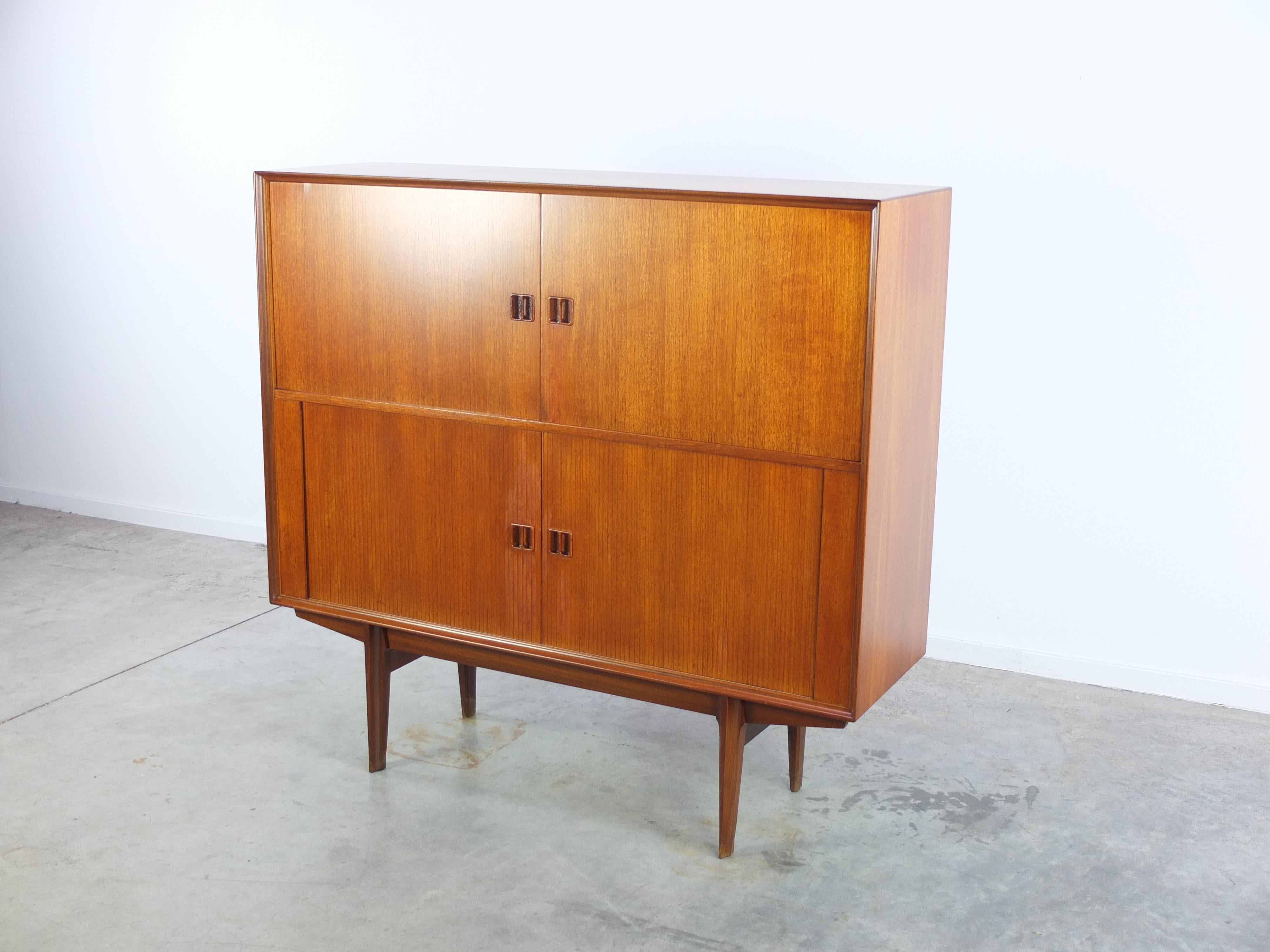 Lovely teak bar cabinet designed by Oswald Vermaercke for V-Form in Belgium during the 1960s. This model comes with two normal doors on the upper side and two beautiful tambour doors below. In mint restored condition.