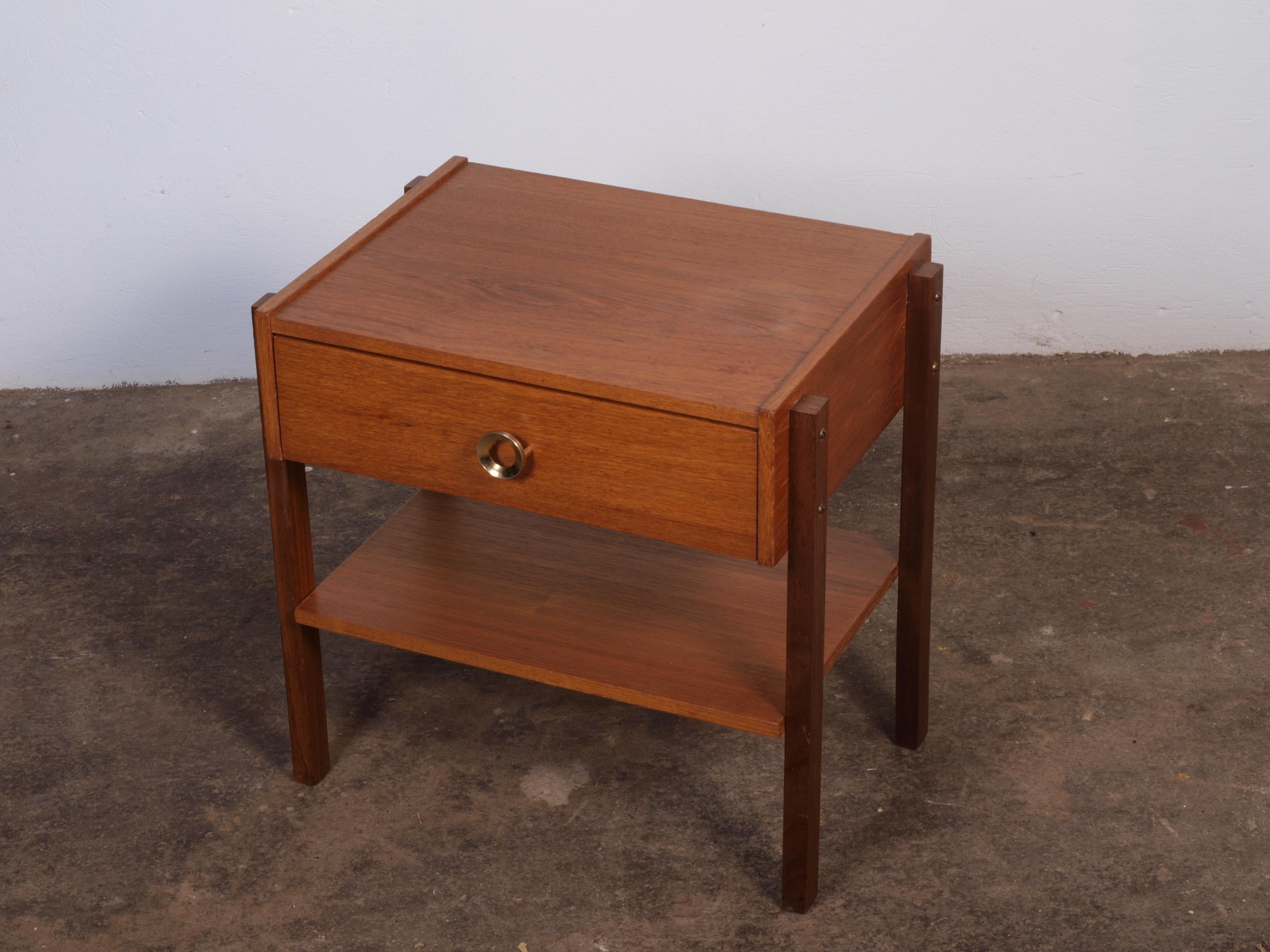 Small, elegant bedside table with drawer in teak wood. Stands sturdy and solid with minor signs of use. No ugly dents, scratches, or marks. The drawer slides smoothly. Would beautifully complement the modern home and decor.