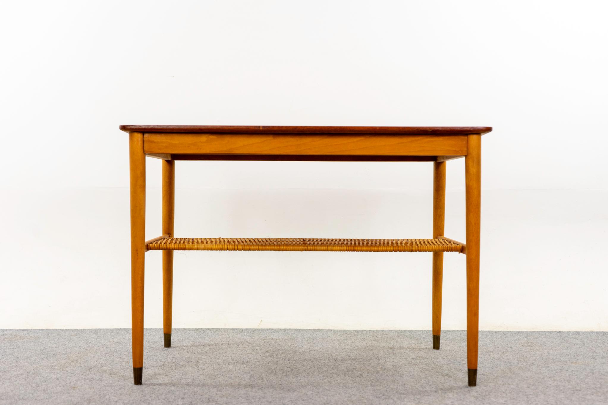 Table basse danoise en teck et hêtre, vers 1960. Magnifique plateau en placage de teck assorti à un livre et pieds effilés en hêtre coiffés de métal ! Belle étagère tissée et aérée. 
