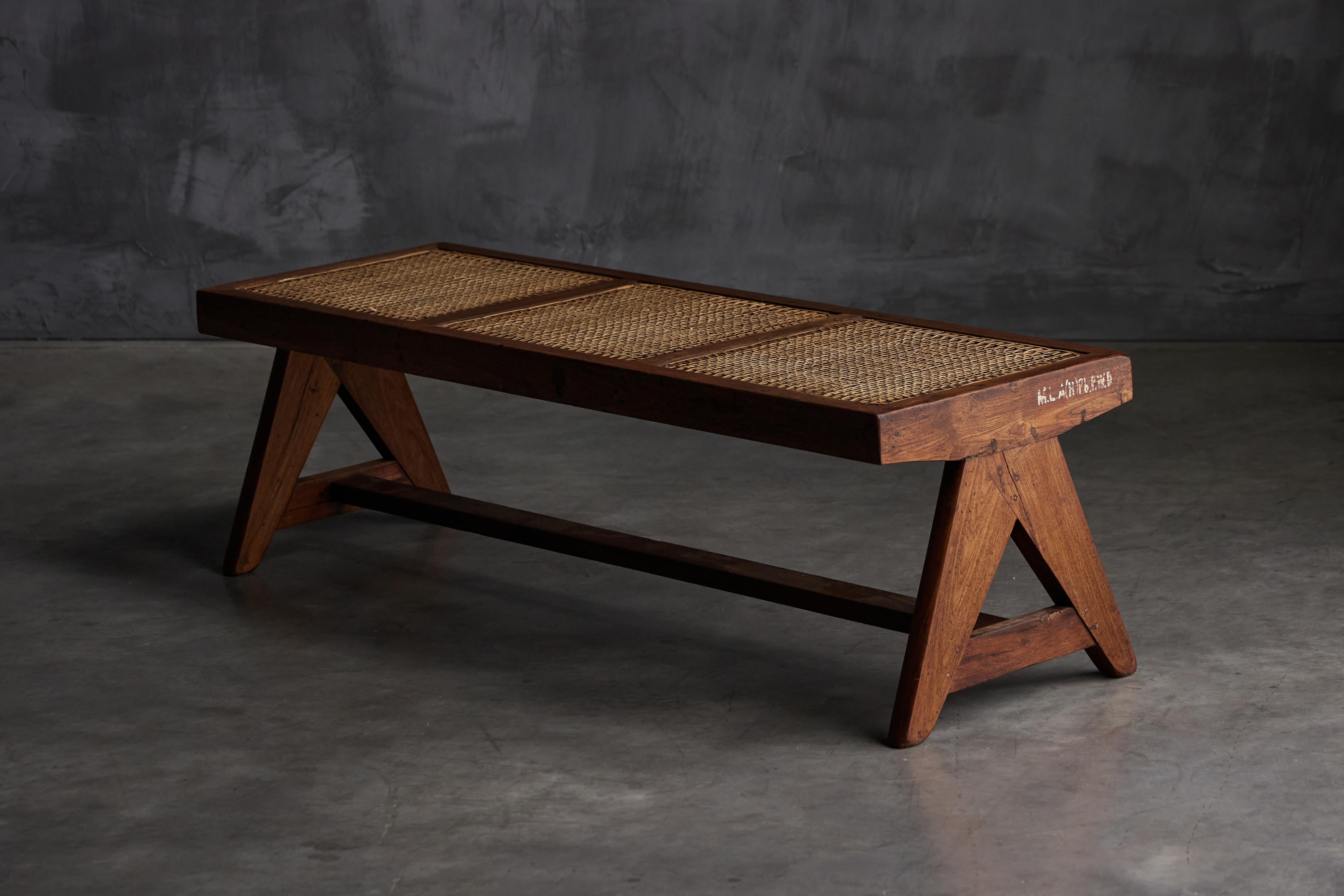 Pierre Jeanneret rectangular PJ-SI-33B bench in teak and cane, designed in the 1950s for the M.L.A. hostels in Chandigarh, India. The cane tabletop is supported by a pair of V-shaped legs, characteristic of Chandigarh creations. Its minimalist
