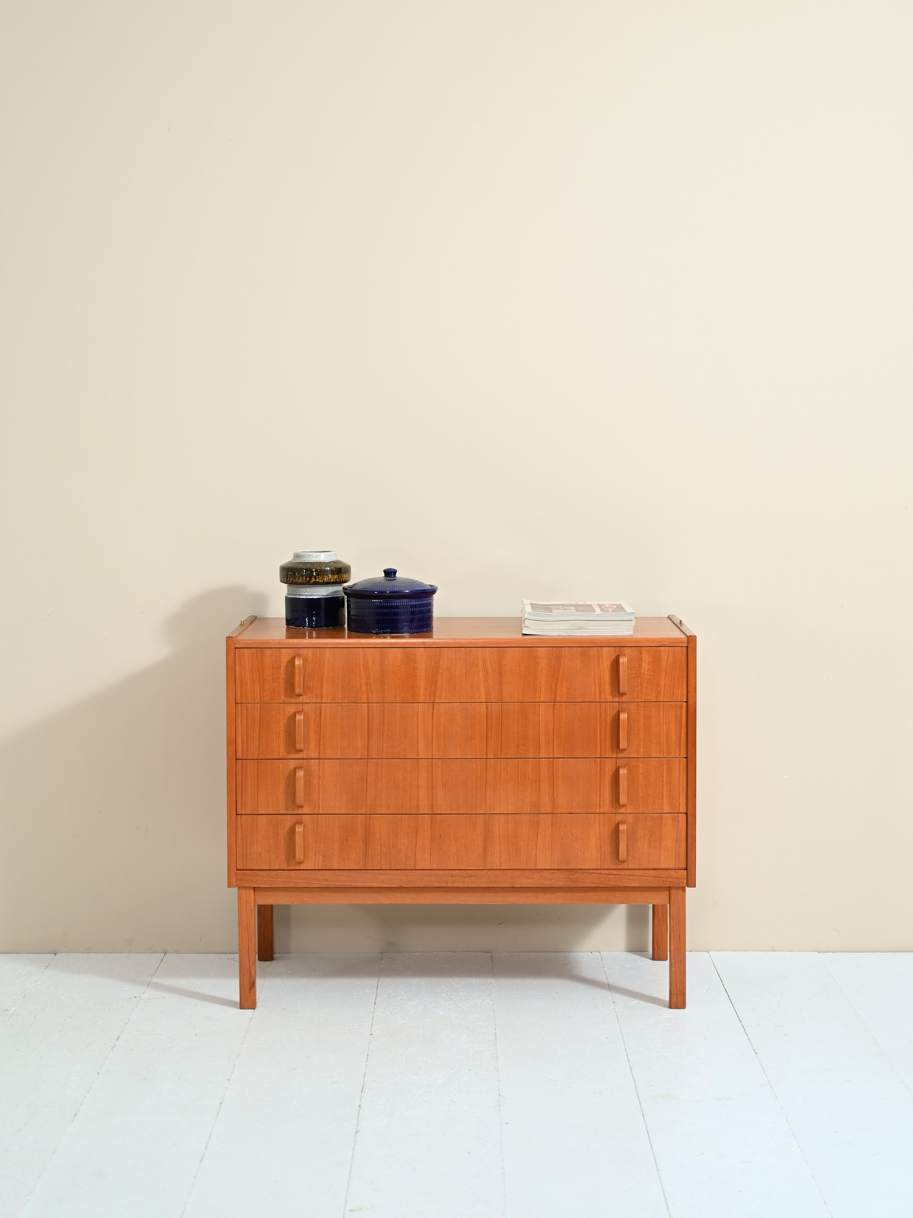 Peculiar teak bookcase cabinet of Scandinavian origin, the manufacture is vintage 1962.

The bookcase consists of 4 shelves, the middle two are adjustable, and four capacious drawers that make up the lower part. 

The curved wood handle of the