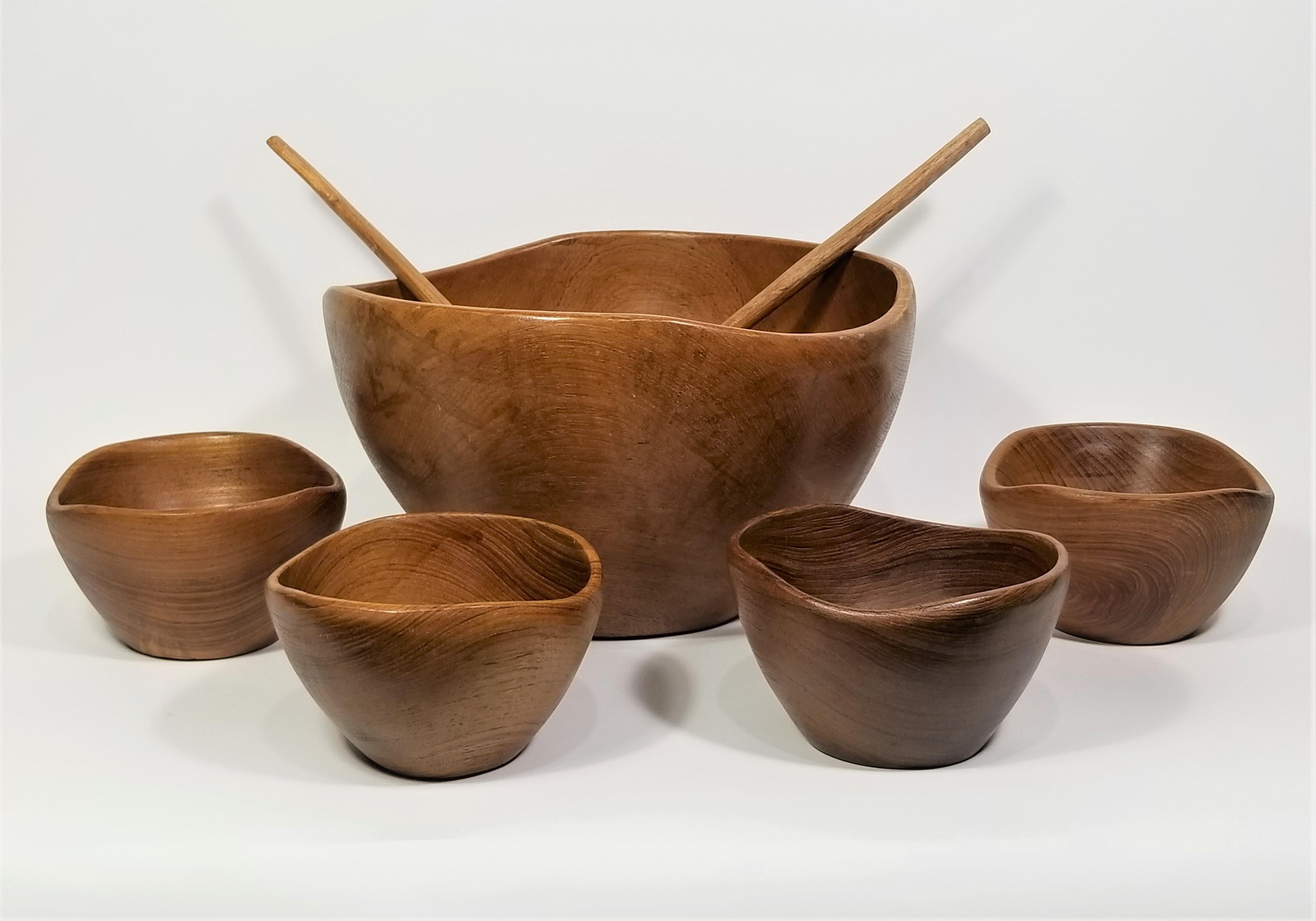 Mid century teak bowls set. Hand Turned. Includes 1 Large bowl, 4 small bowl and 2 serving utensils. 

Measurements:
Big Bowls Height: 7.25 inches
Big Bowls Diameter: 12.0 inches

Small Bowls Height: 3.5 inches
Small Bowls Diameter: 5.88