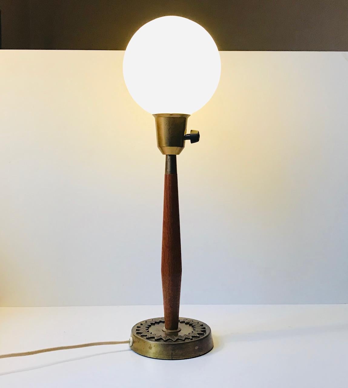 - Scandinavian Modern table light designed by Hans Bergström
- Manufactured by ASEA in Sweden during the early 1950s
- Teak stem with brass socket and brass base with leaf decor in bronze
- Its mounted with a loosely fitted opaline glass